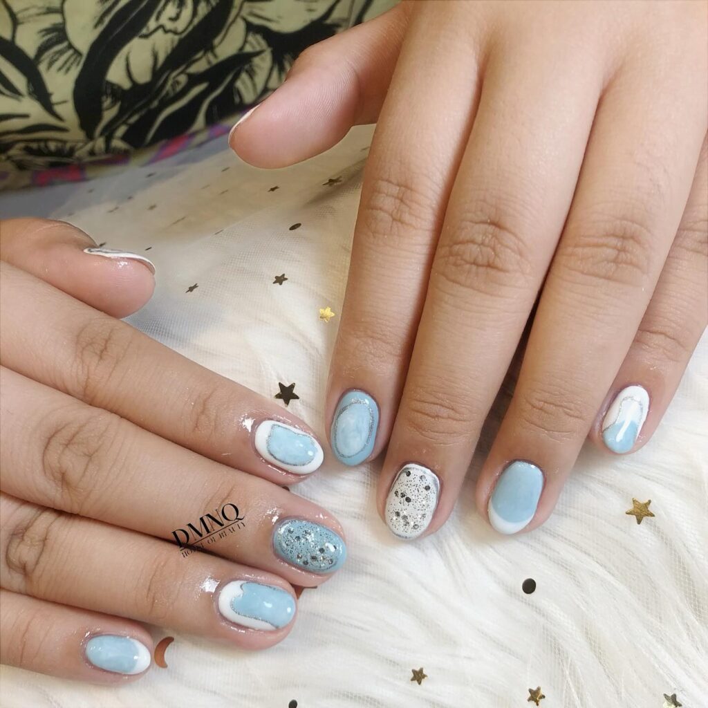 Sky Blue Short Nails with Soft White Swirls and Speckled Accents