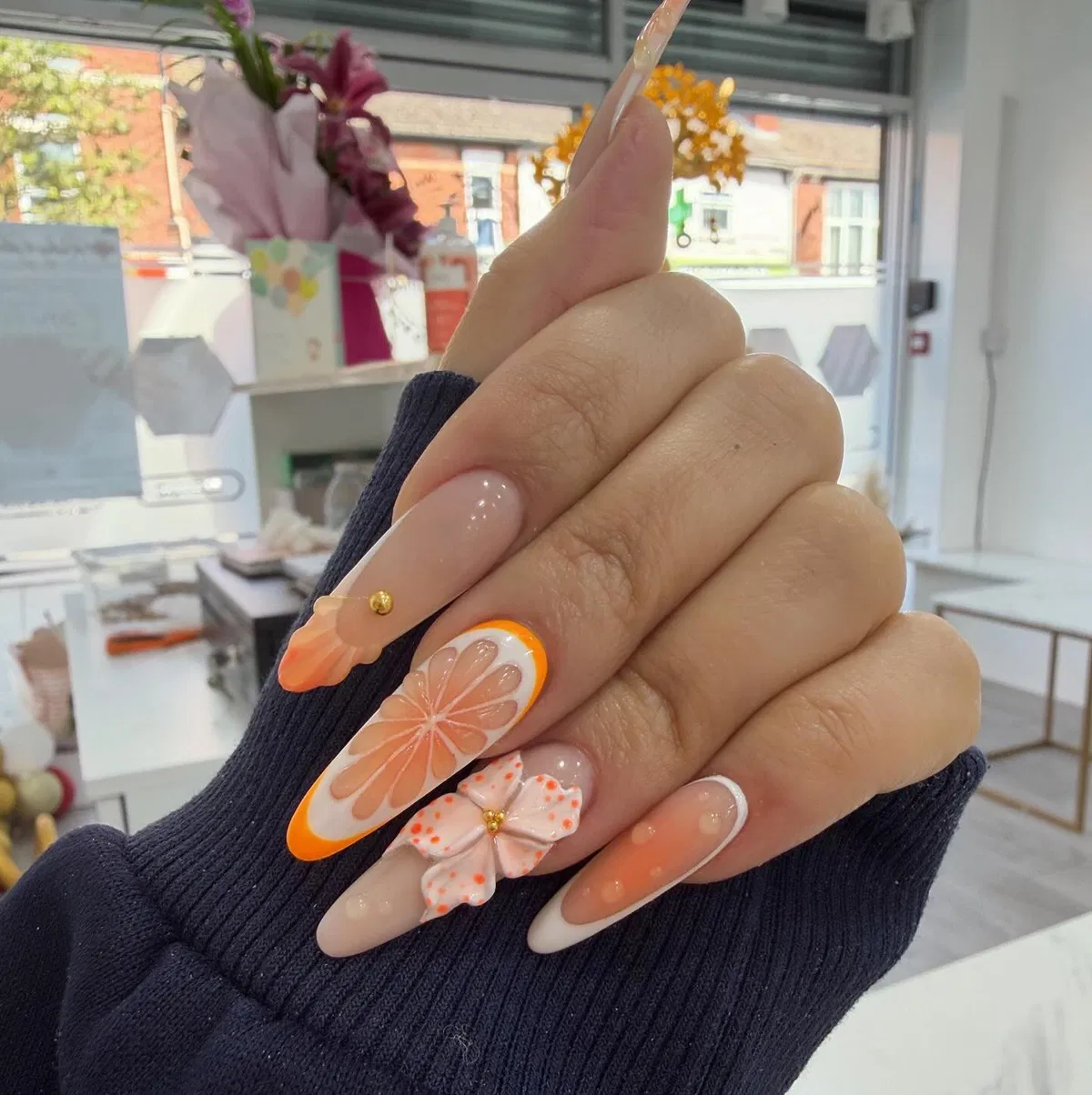 Orange French tips with citrus-slice and 3D flower accent