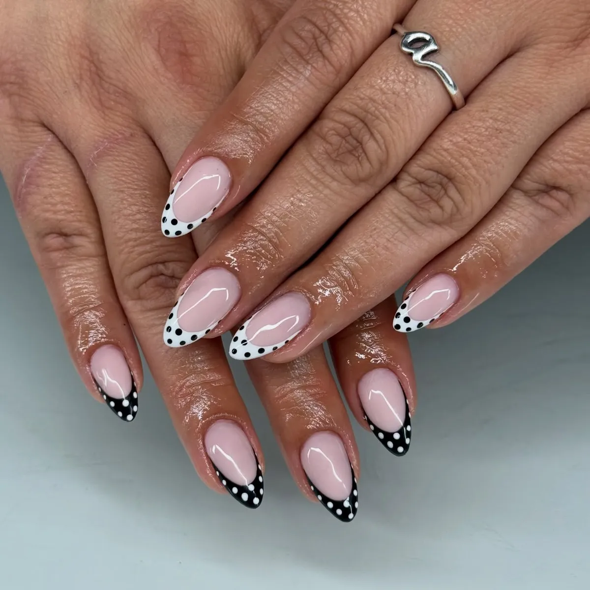 Polka-dot French tips in black and white on pale pink base