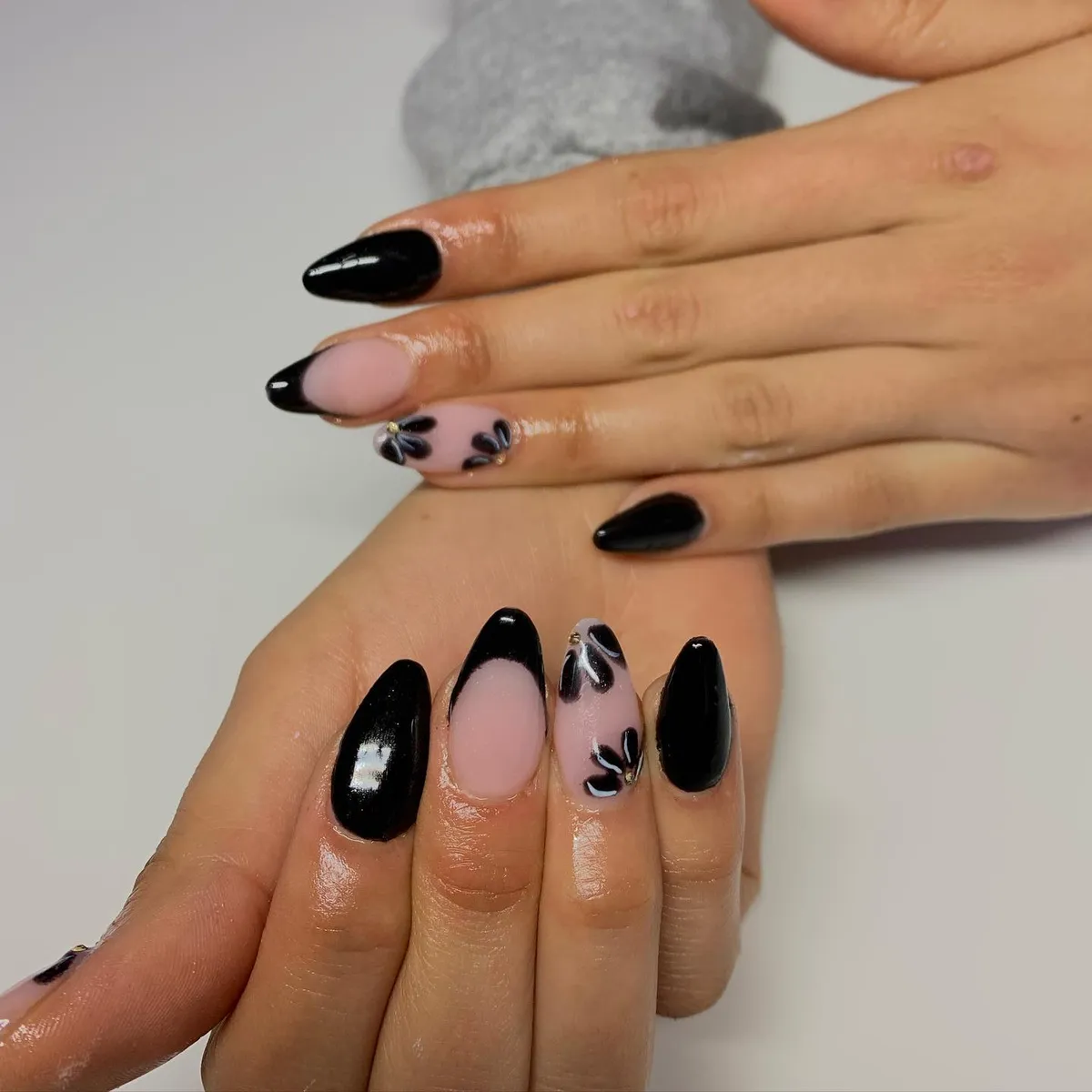 Mixed solid black and nude nails with black floral accents