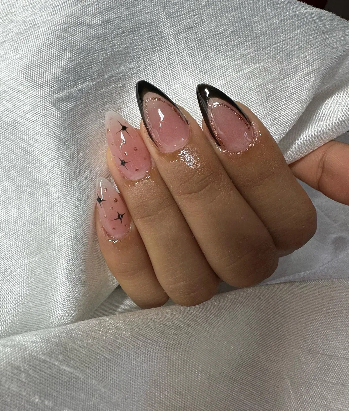 Thin black outlined tips with starburst accents on nude base