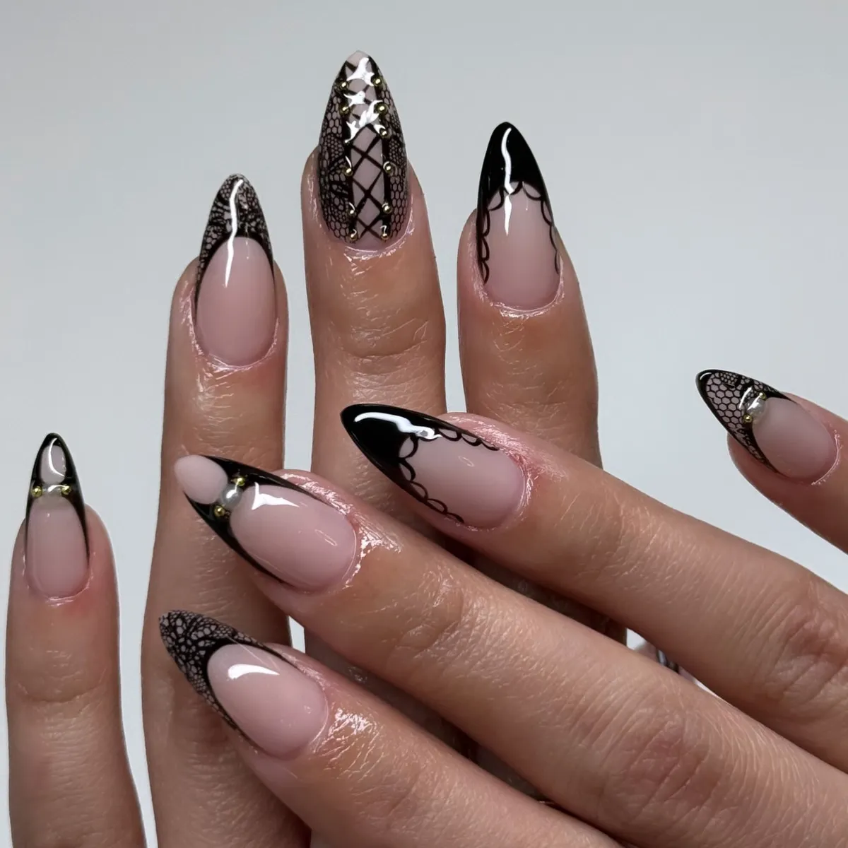 Black lace-pattern French tips with lattice and gold stud accents