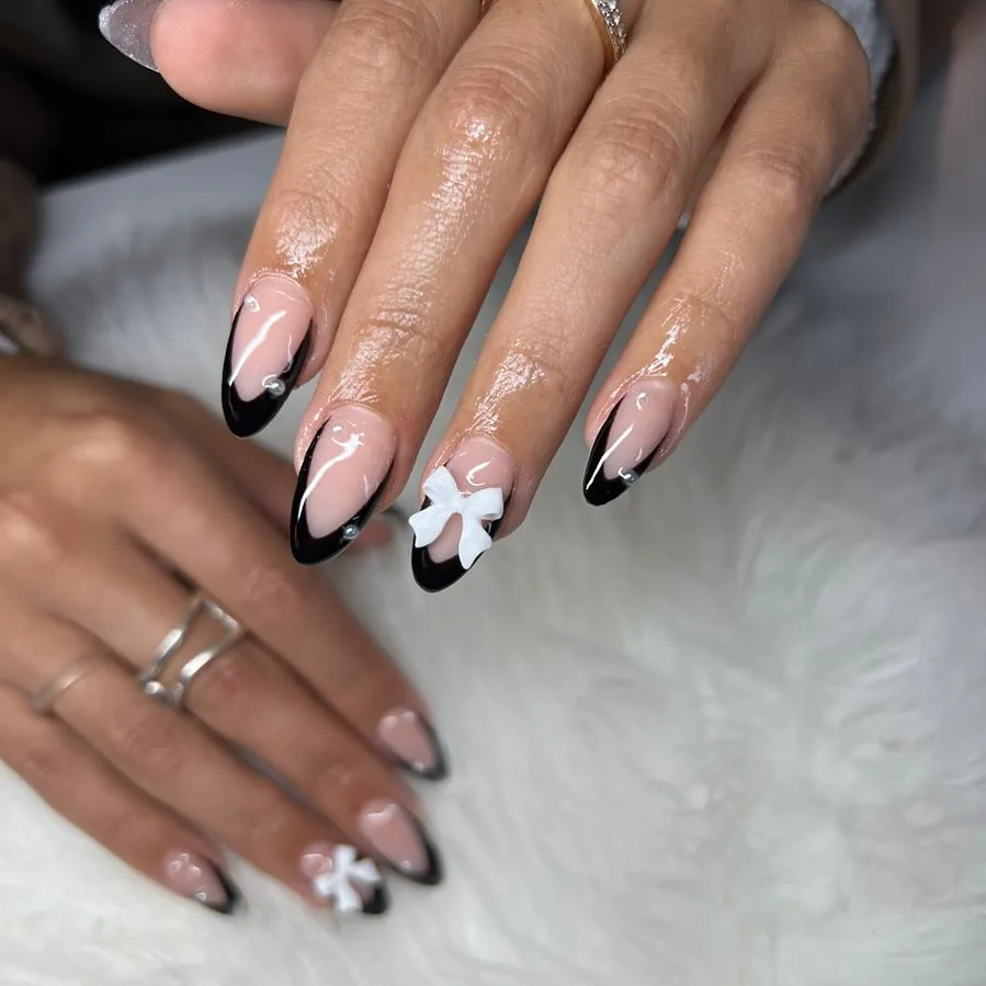 Classic black French tips with a raised white bow accent