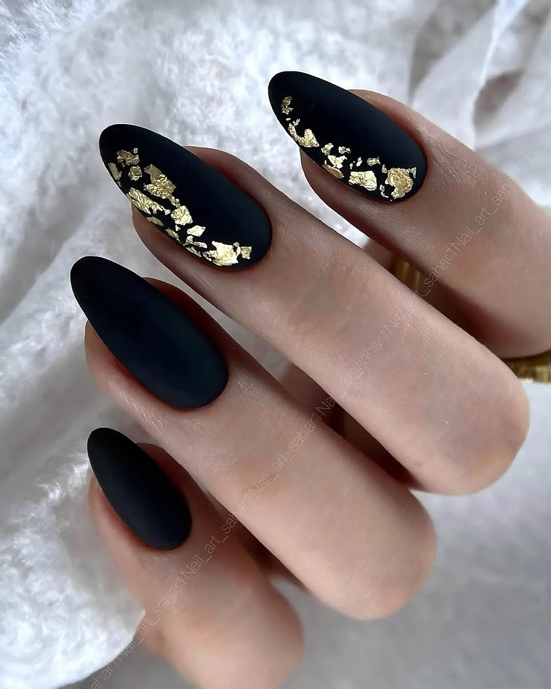 Matte black nails with diagonal gold foil band