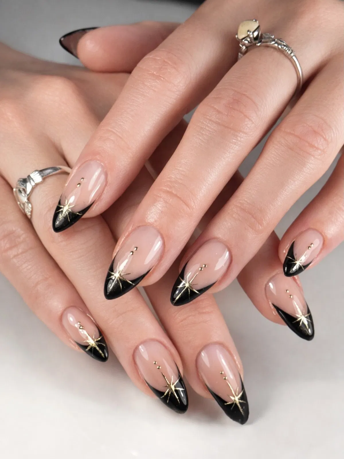 Black French tips with gold starbursts and studs