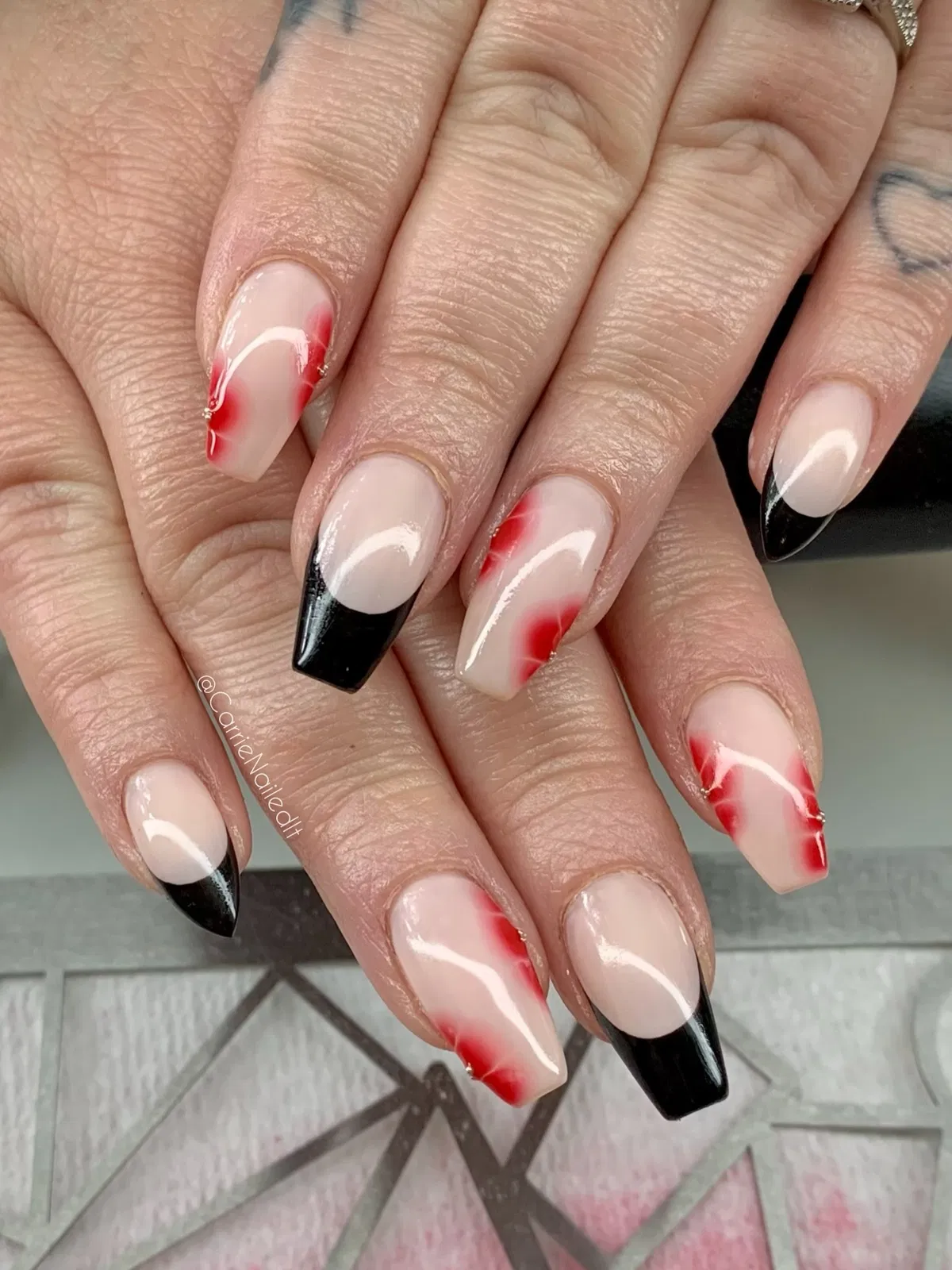 Nude base with black tips and red blurred accents