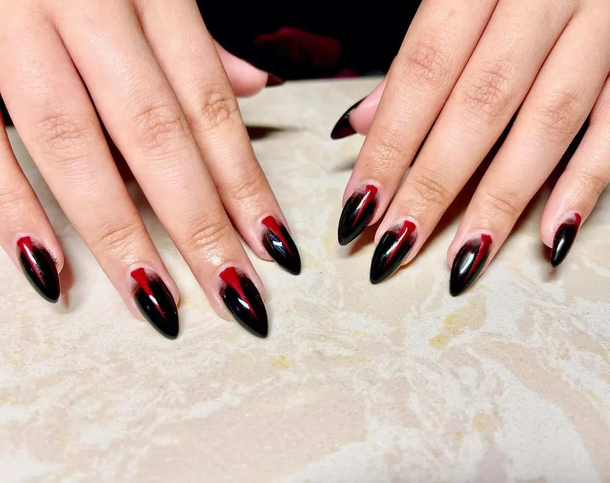 Black stiletto nails with red center accents