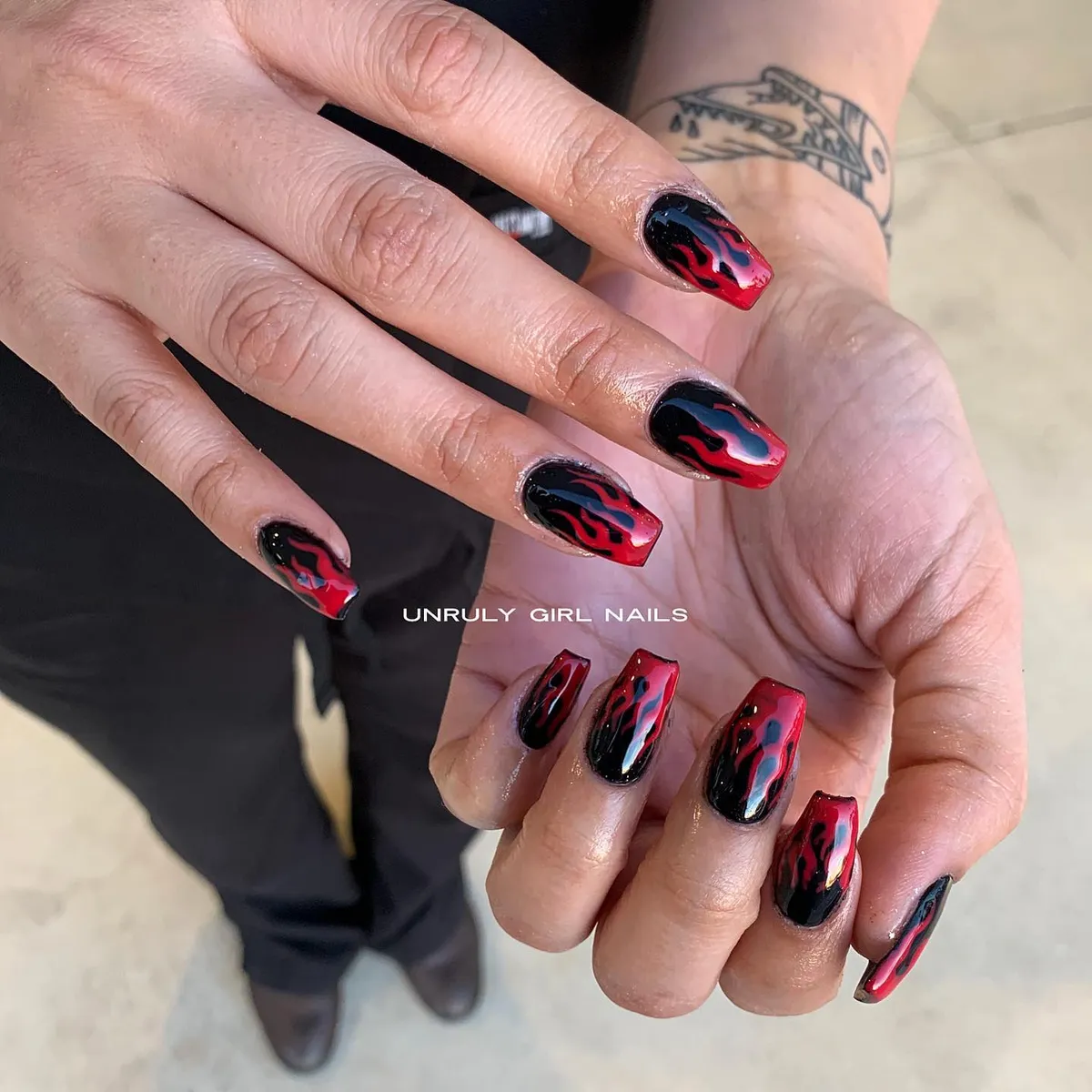 Black nails with red flame pattern and text overlay