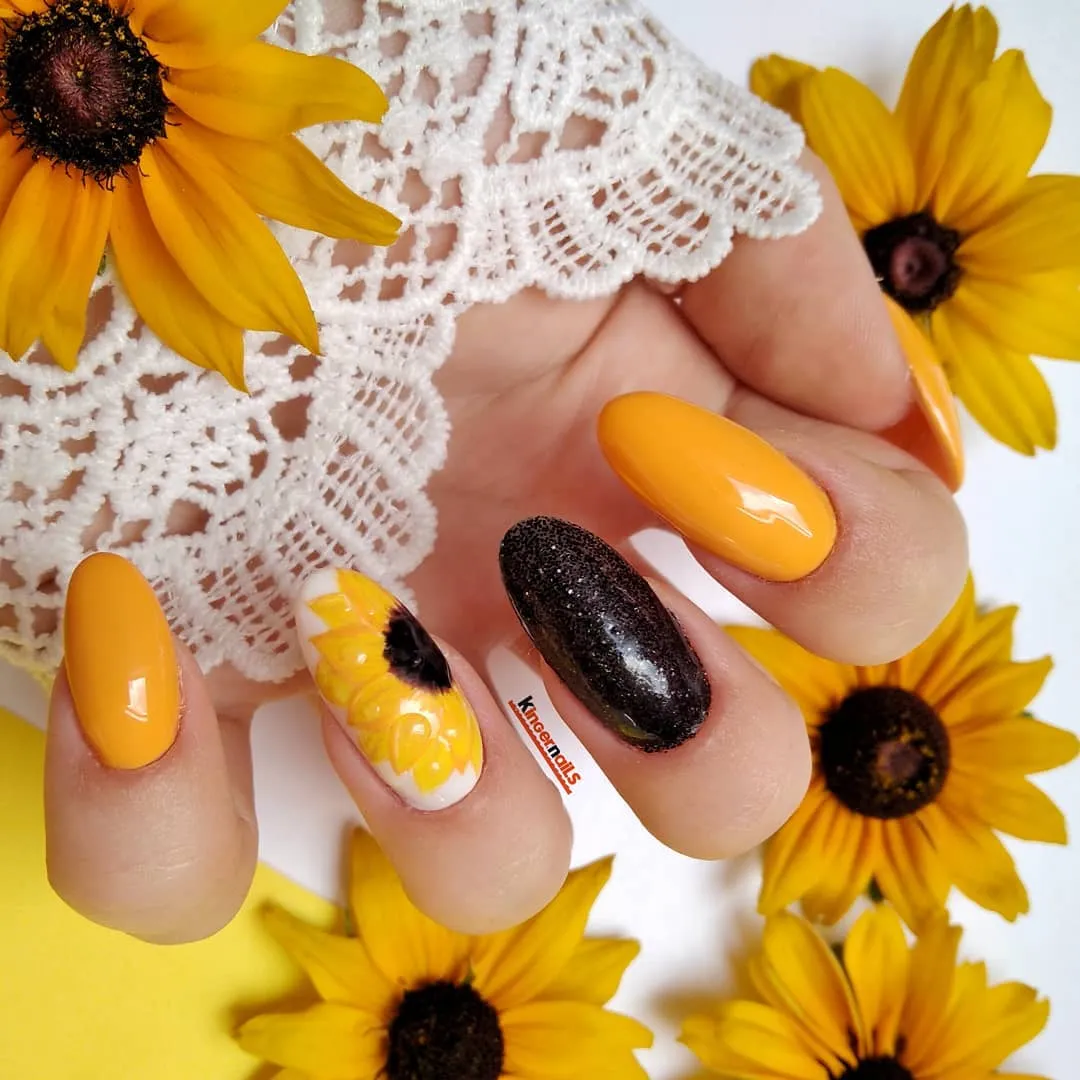 Orange-yellow gloss with a black glitter accent and a white floral feature nail