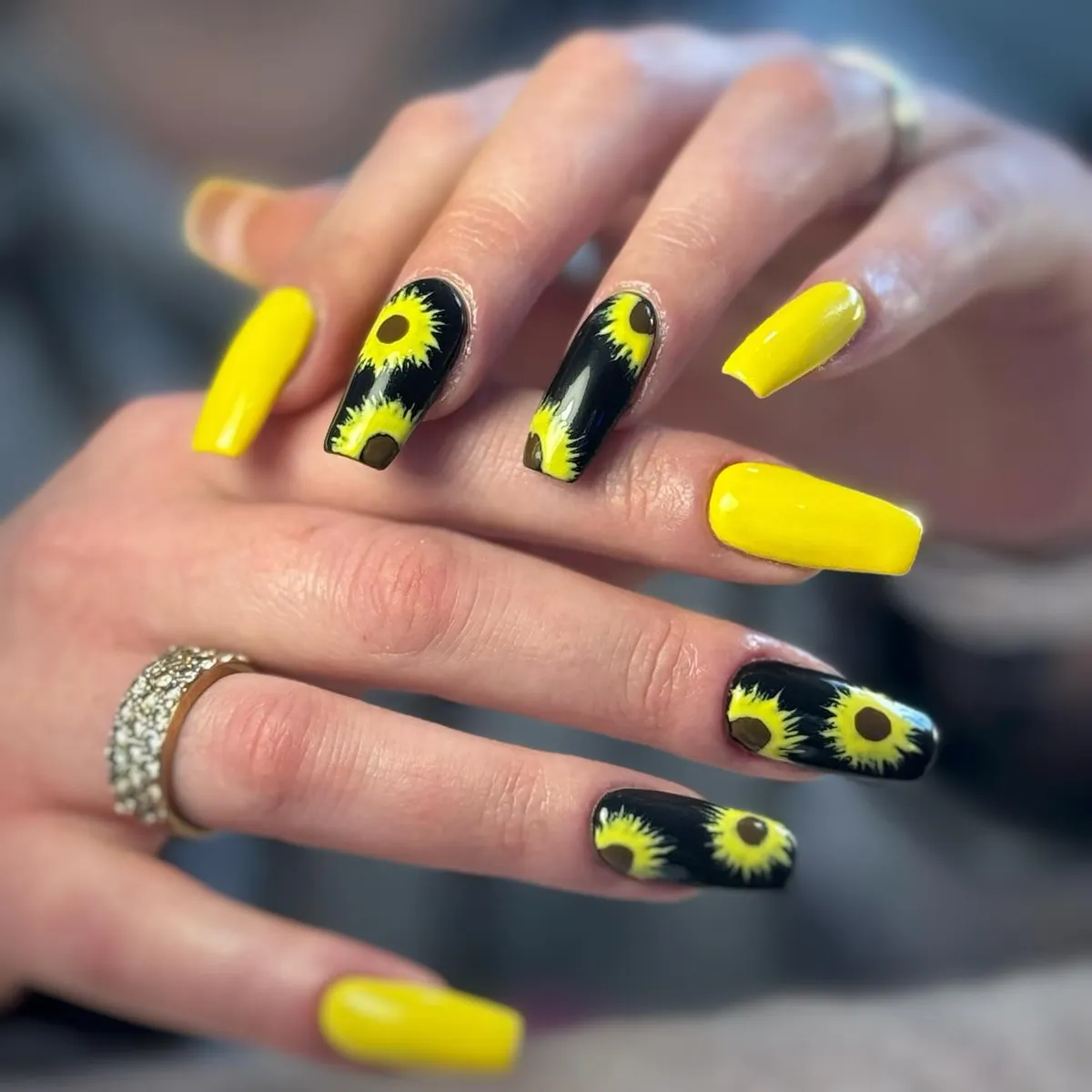 Glossy yellow solids with black sunflower-pattern accent nails