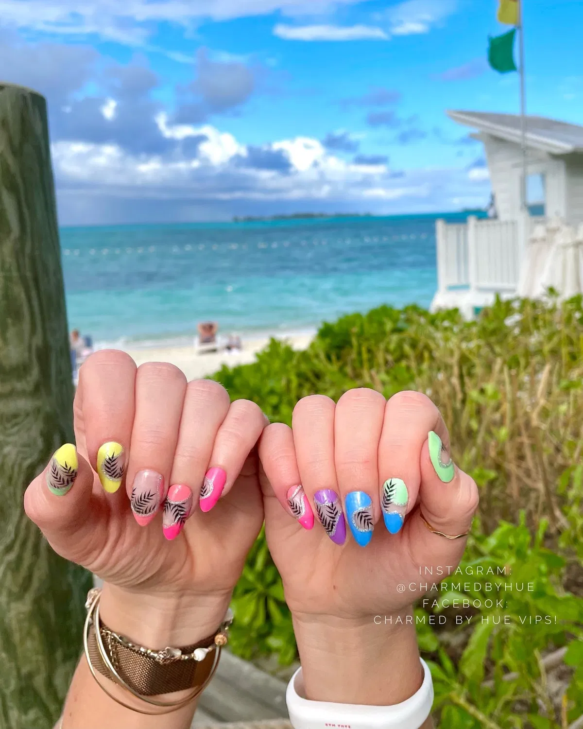 Bright multicolor nails with black leaf silhouettes (outdoor shot)
