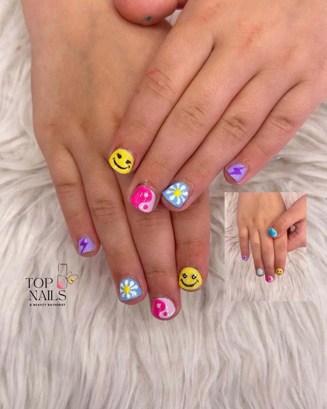 Smiley faces and daisies on bright short nails