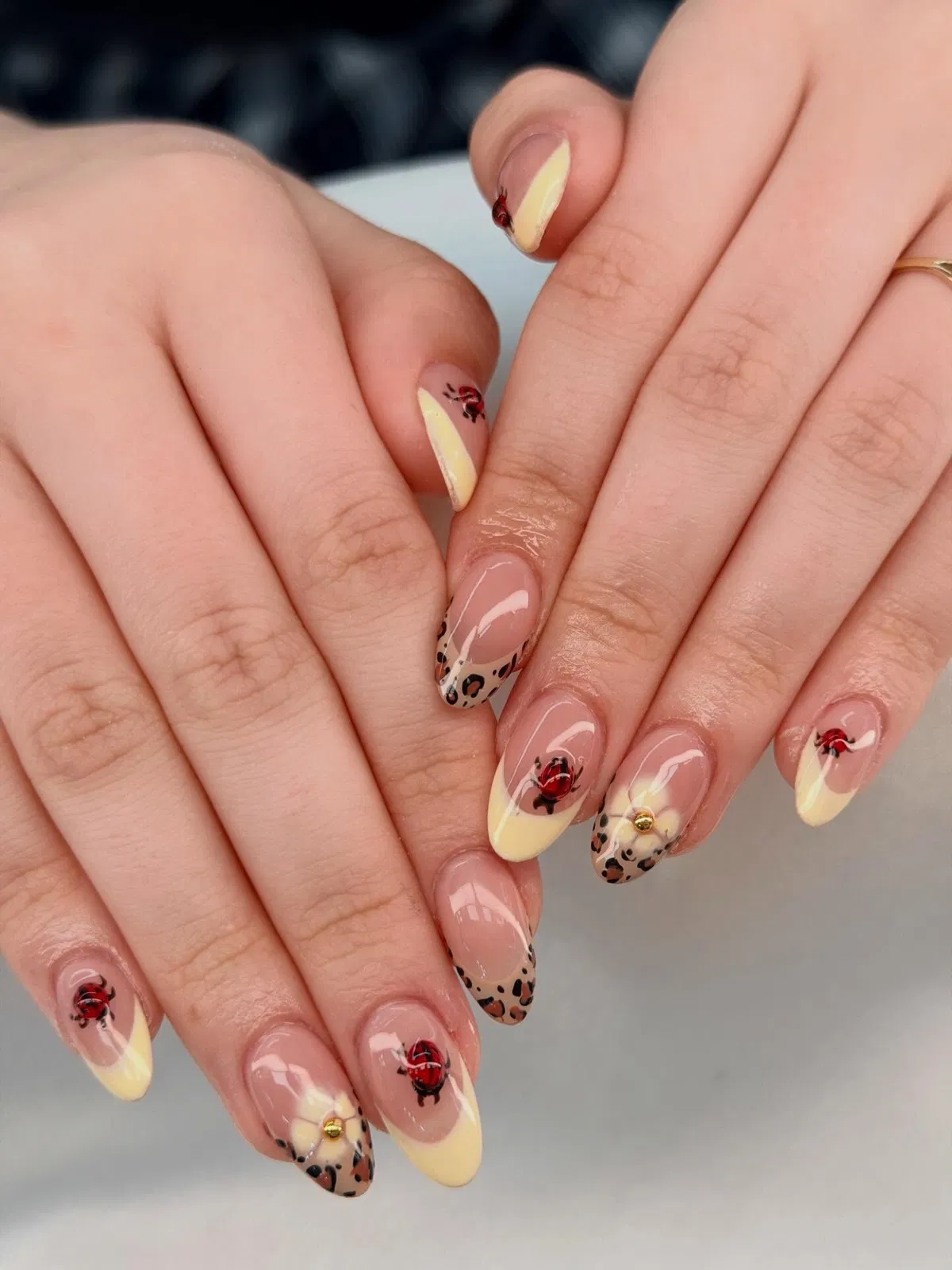 Pale yellow French tips with leopard spots and red rose accents