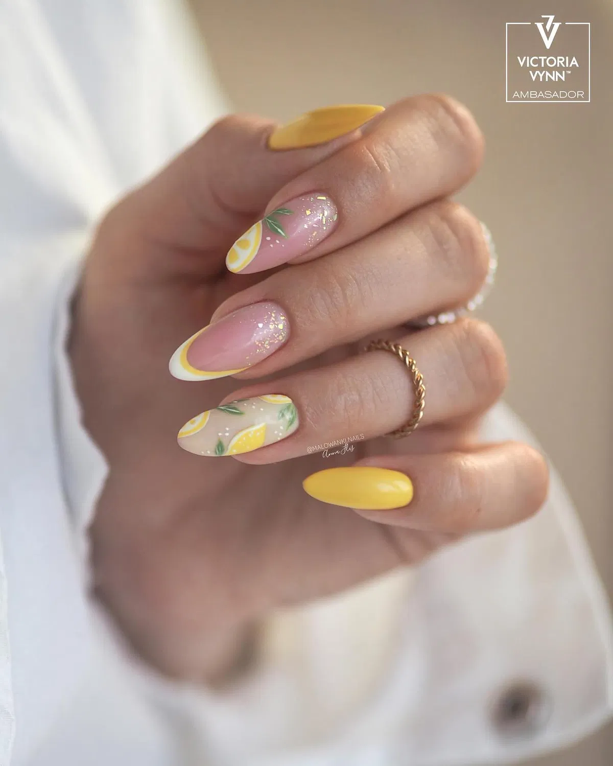 Soft yellow accents with curved French tips and glitter detail