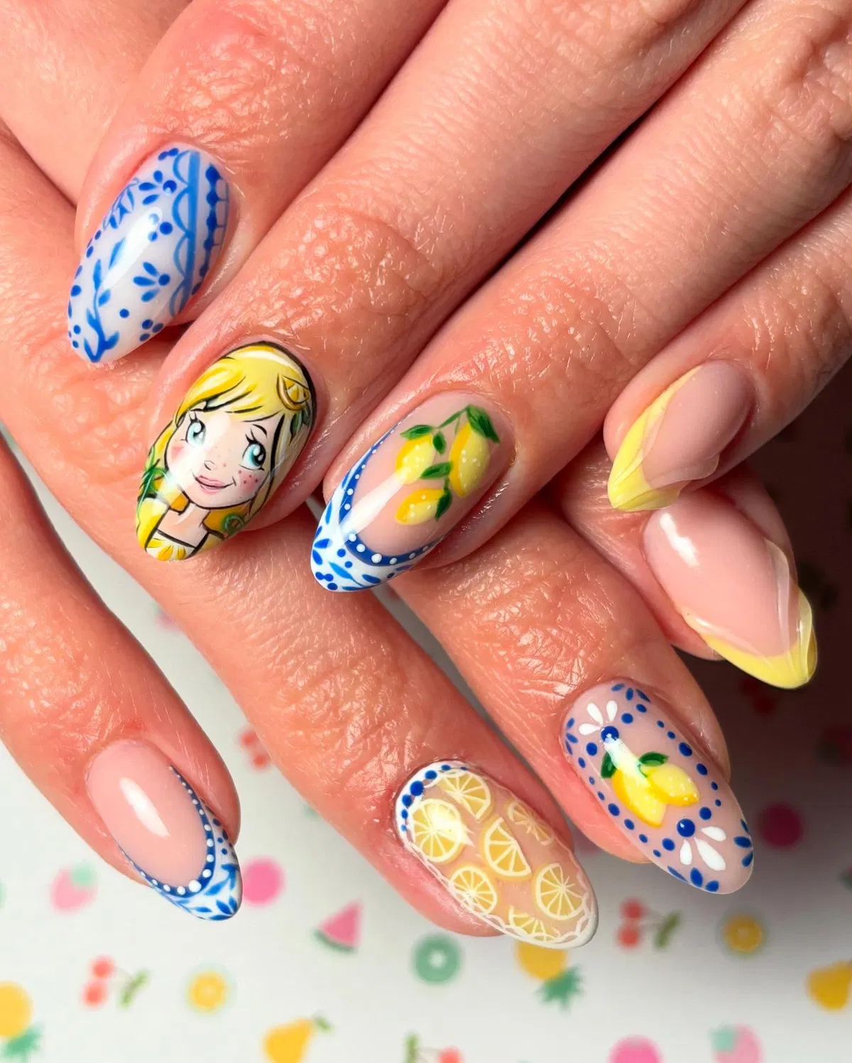 Lemon motifs with blue dotted borders and a character accent nail