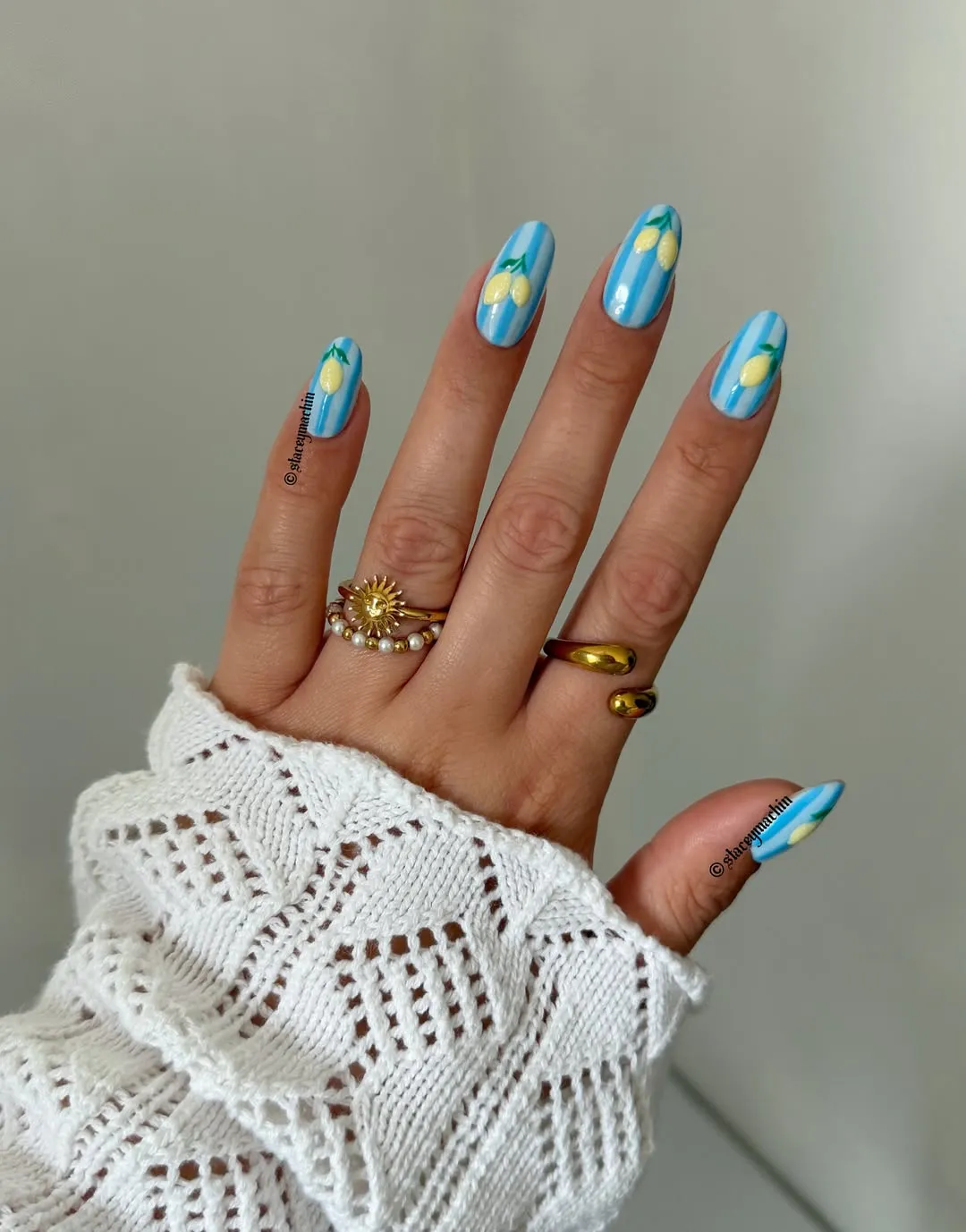 Blue striped nails with small yellow lemon motifs