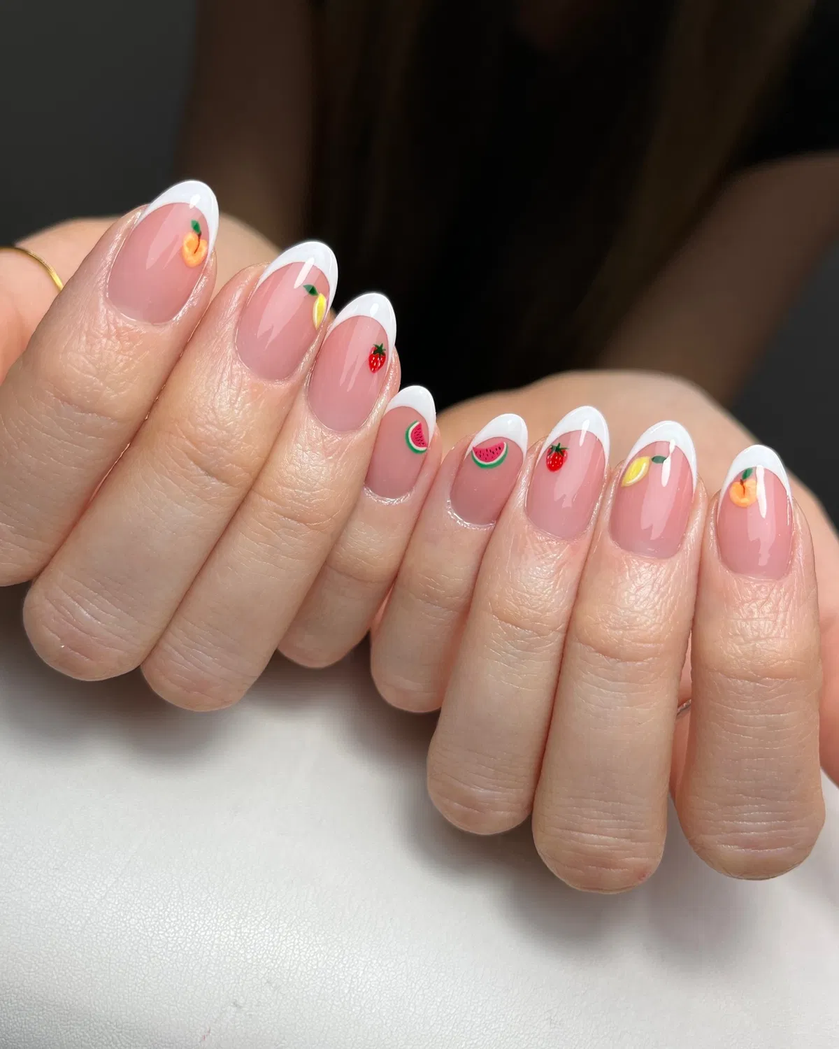 White French tips with tiny fruit accents including a lemon-like motif