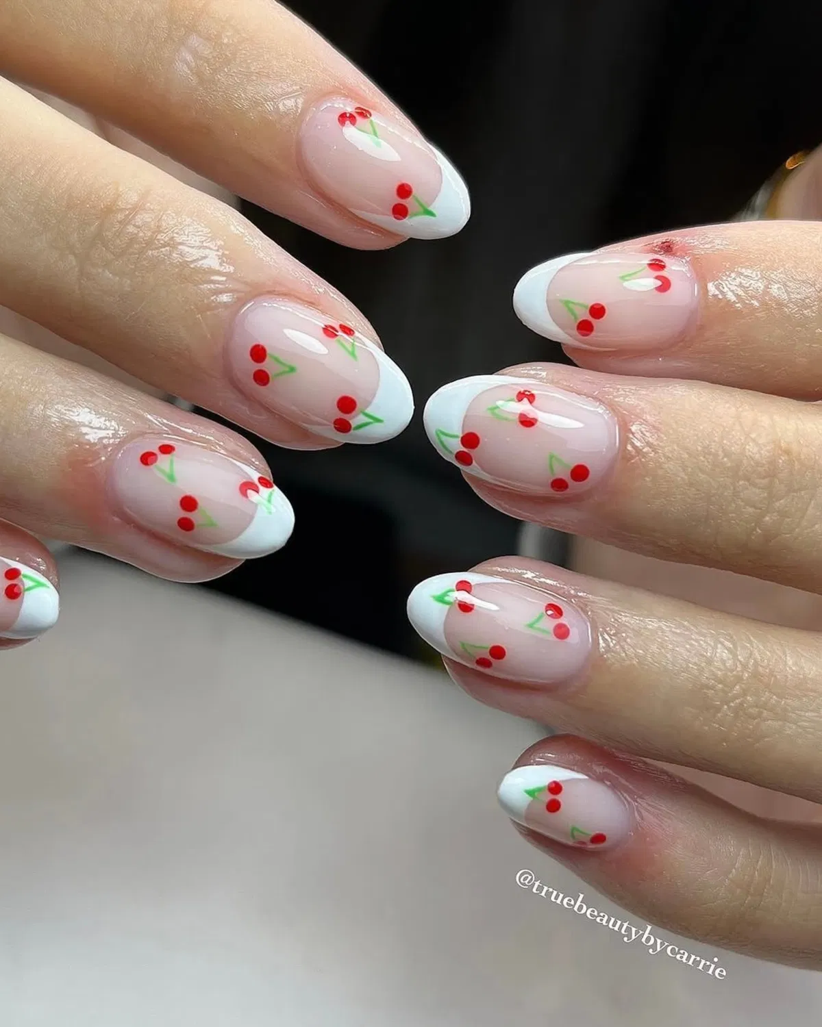 White French tips with red cherry-like motifs