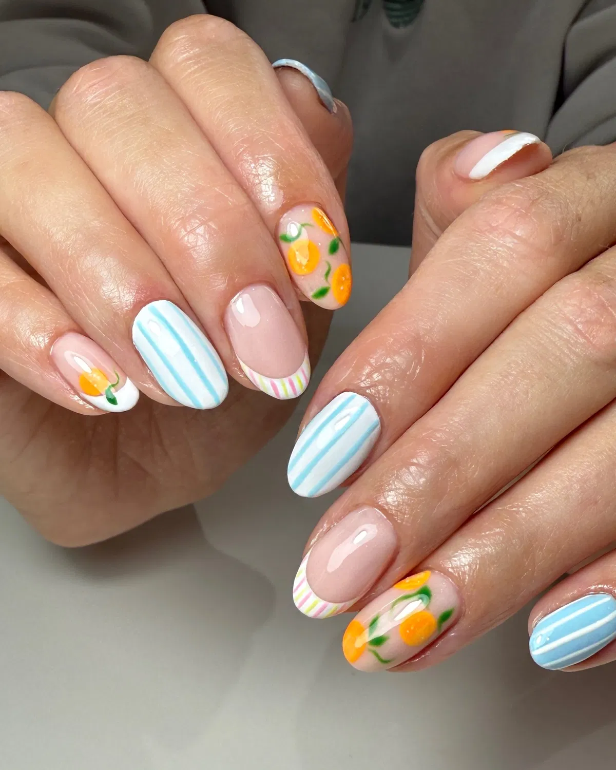 Blue pinstripes with citrus-and-leaf accent nails