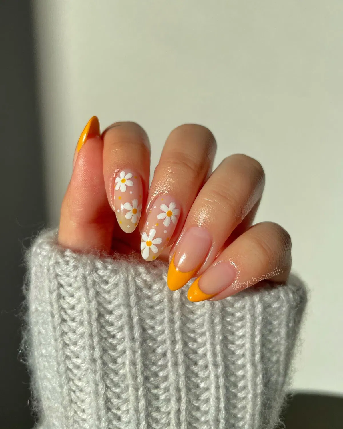 Orange French tips with white daisy accents