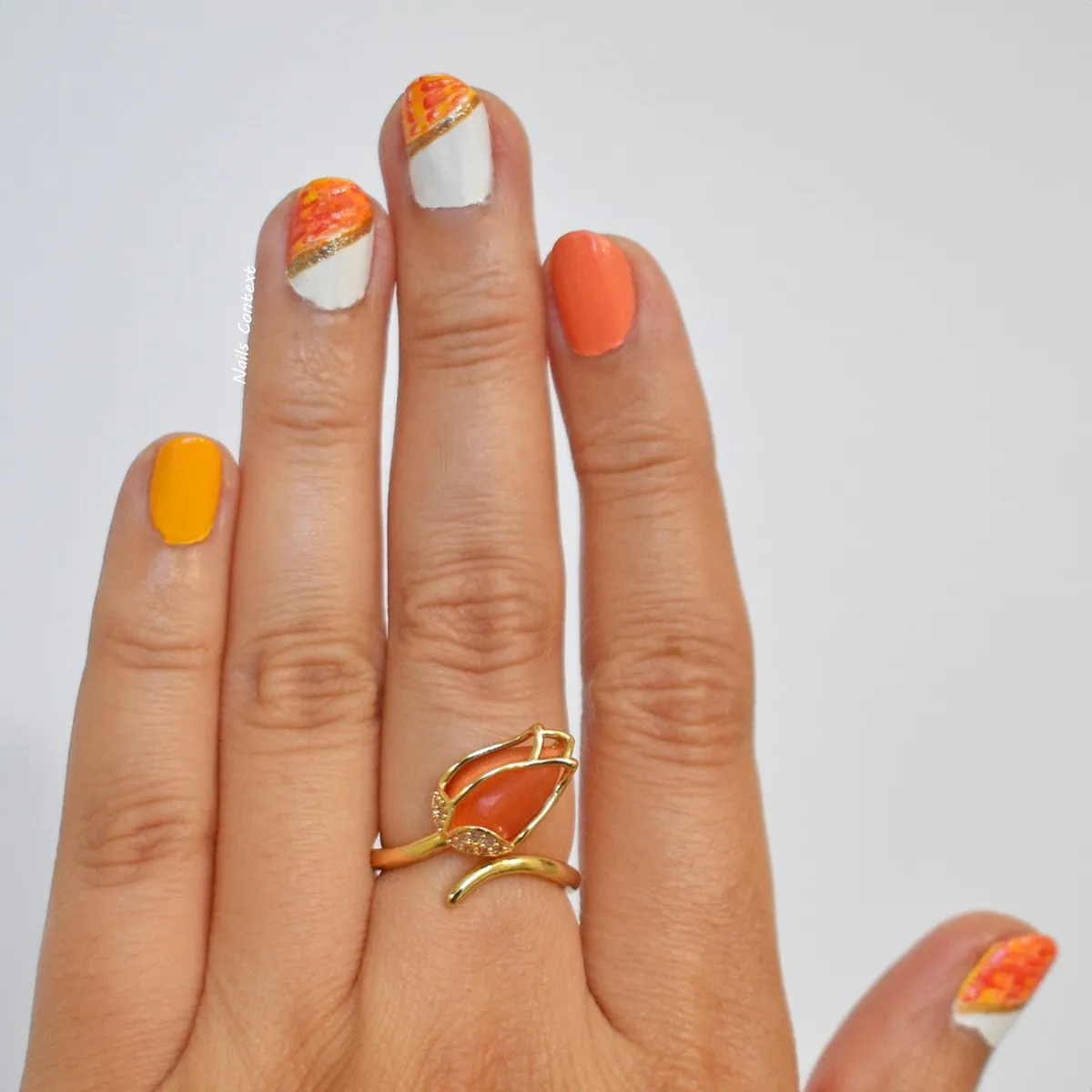 Orange and white diagonal nails with thin gold stripe