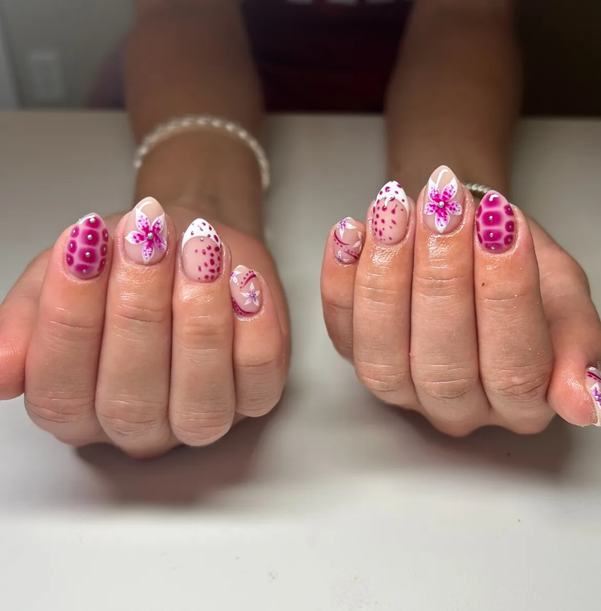 Nude base with magenta dots, white curves, and floral accents