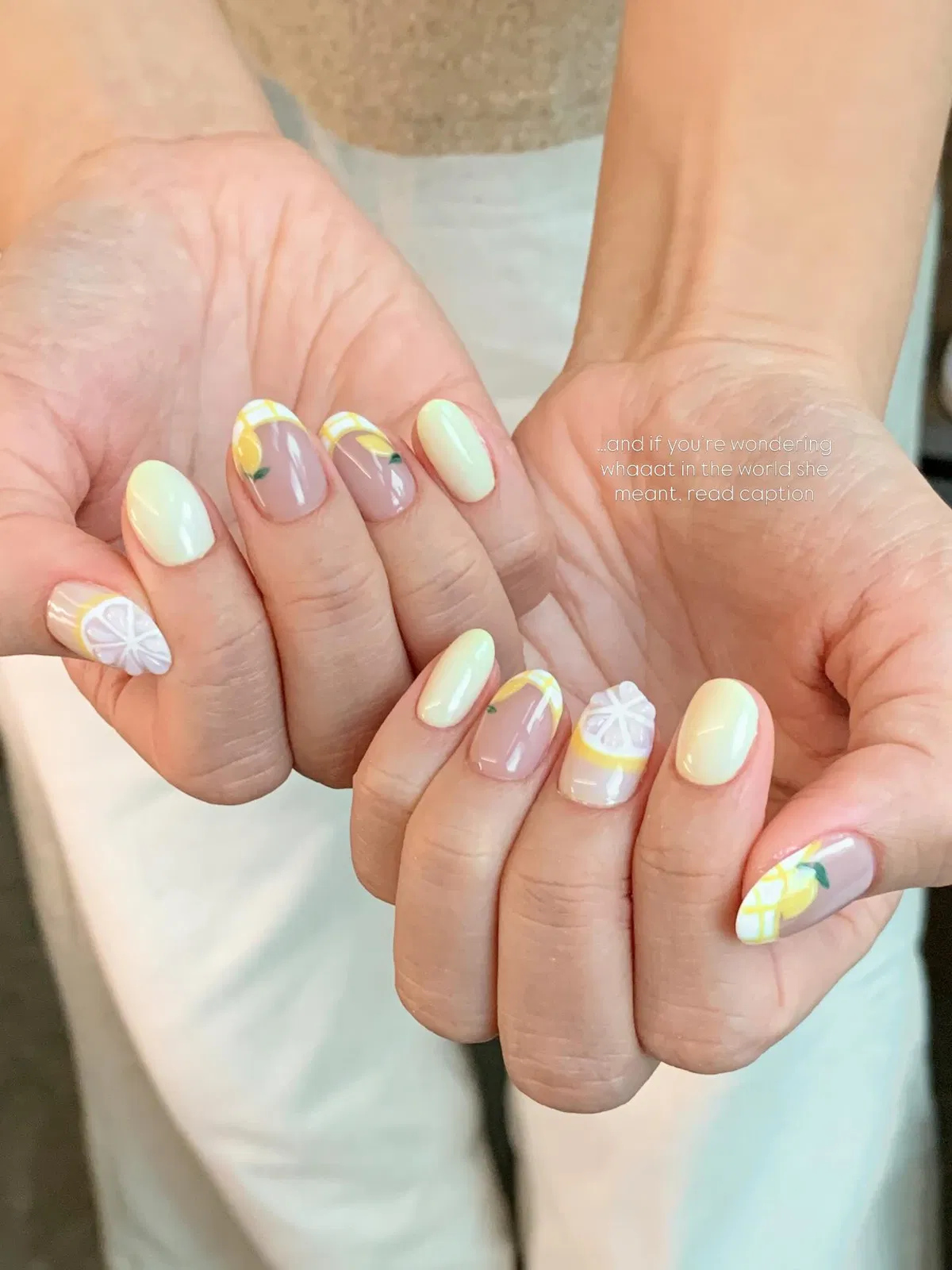 Cream solids with grid accents and a citrus-slice feature nail