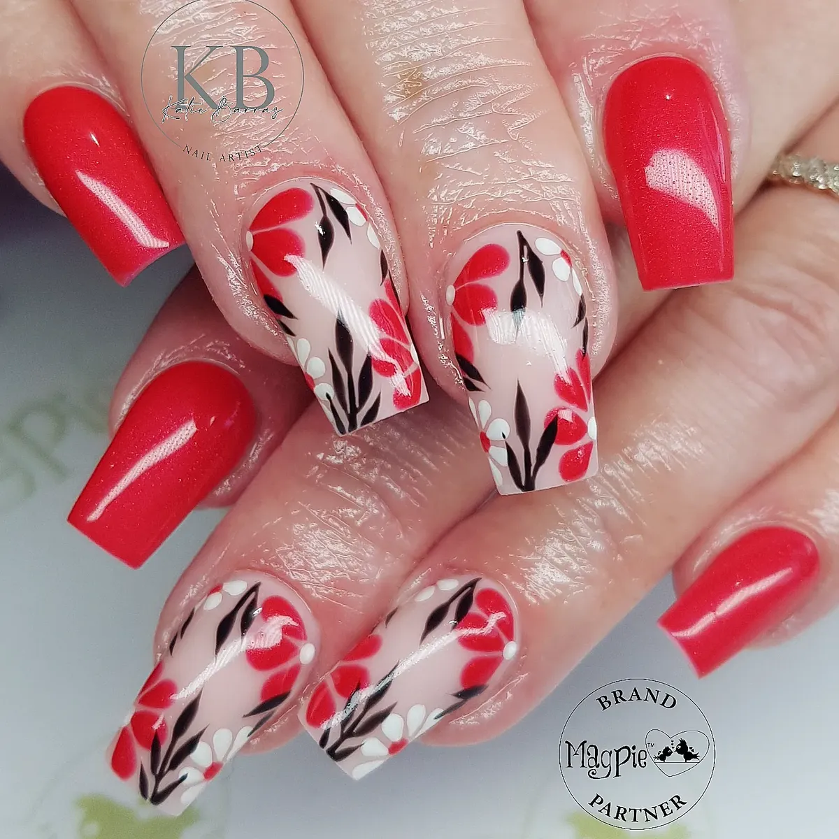 Shimmery red with floral-and-leaf accent nails