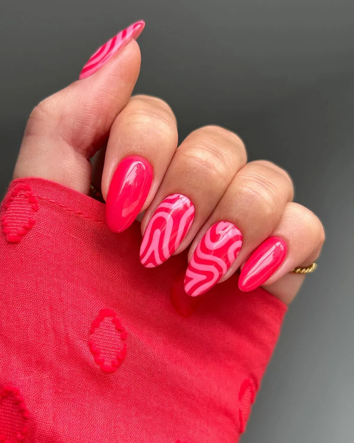 Hot pink glossy nails with wavy swirl accents