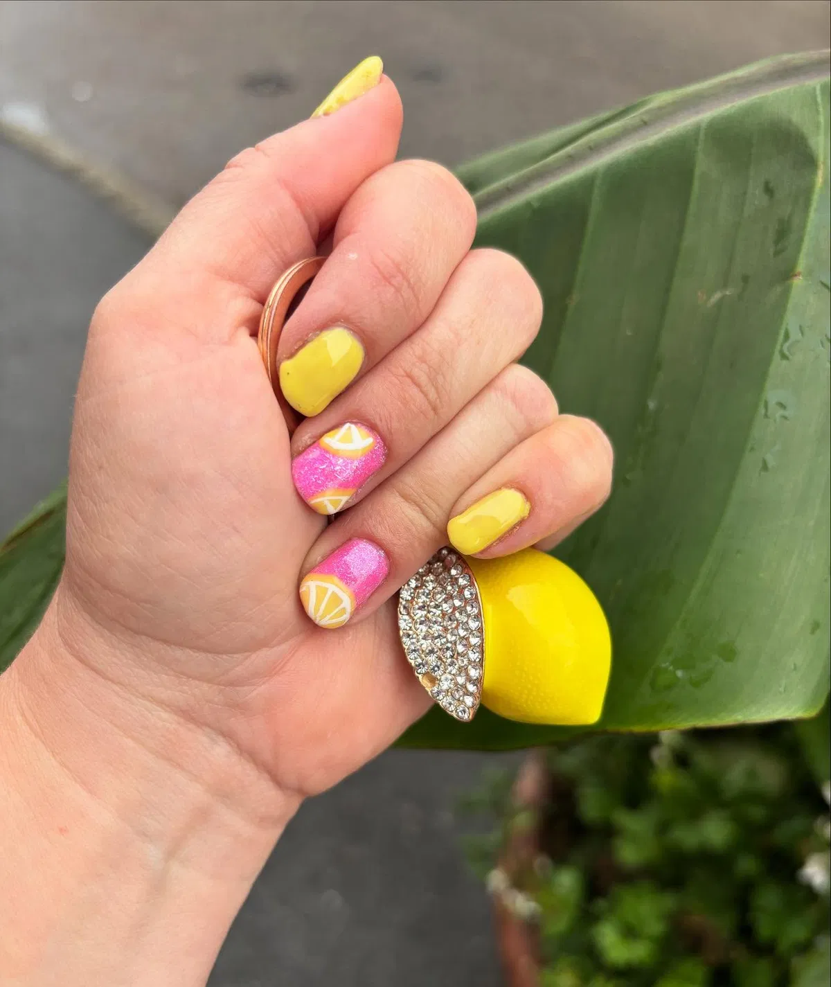 Bright yellow and pink nails with citrus slice accents
