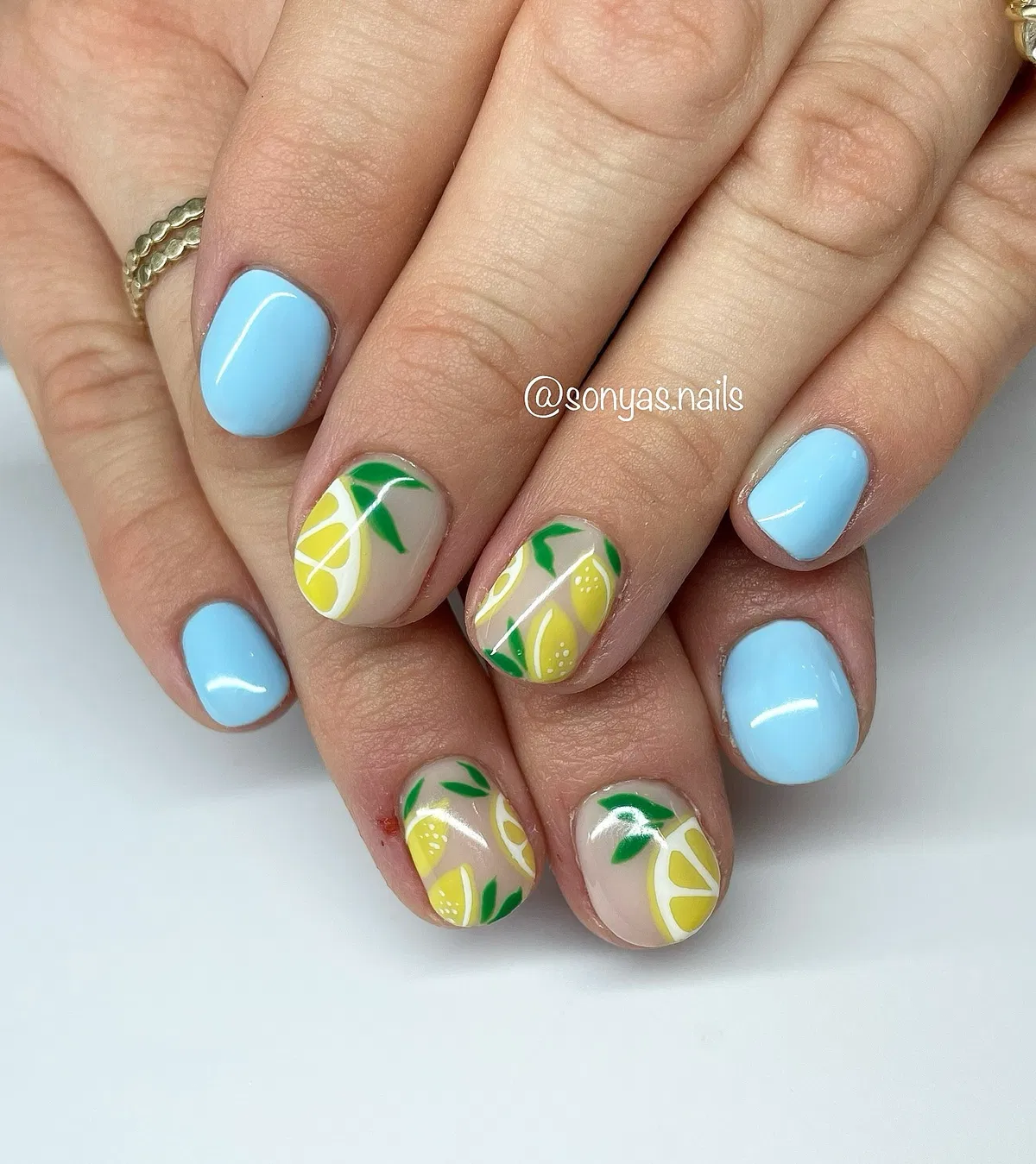 Sky blue solids with nude lemon-and-leaf accent nails