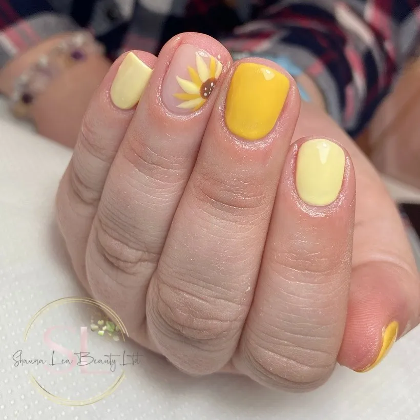 Short yellow nails with one sunflower accent
