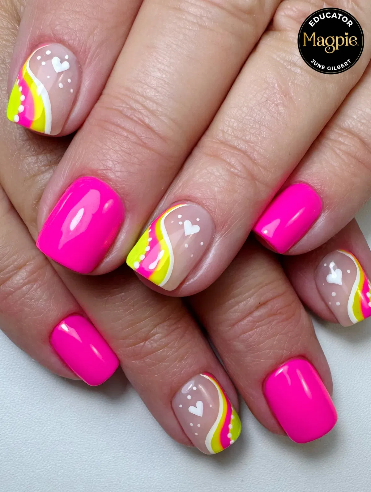 Neon pink set with nude accent nails, curved stripes, and white hearts