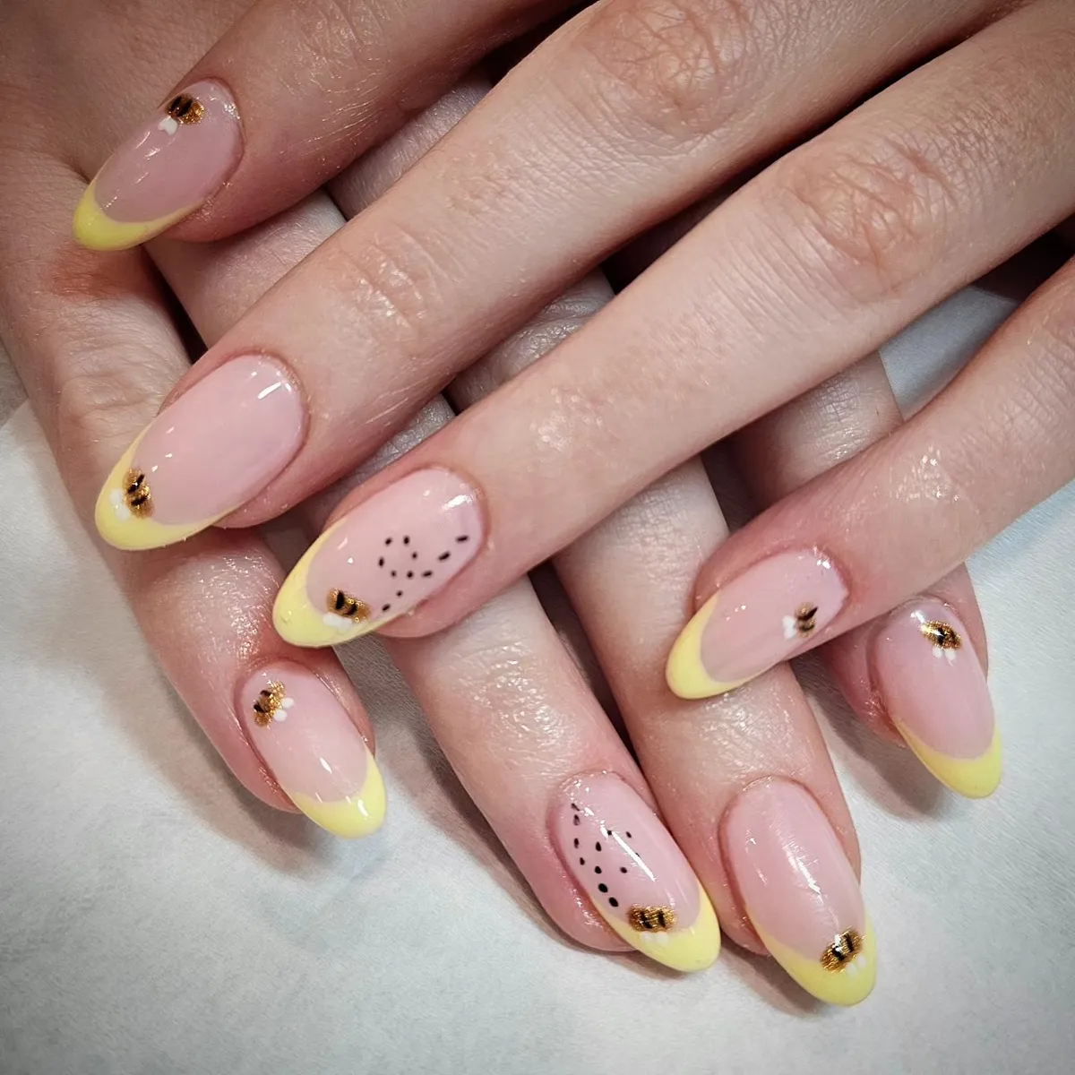 Pale yellow French tips with bee and dot details