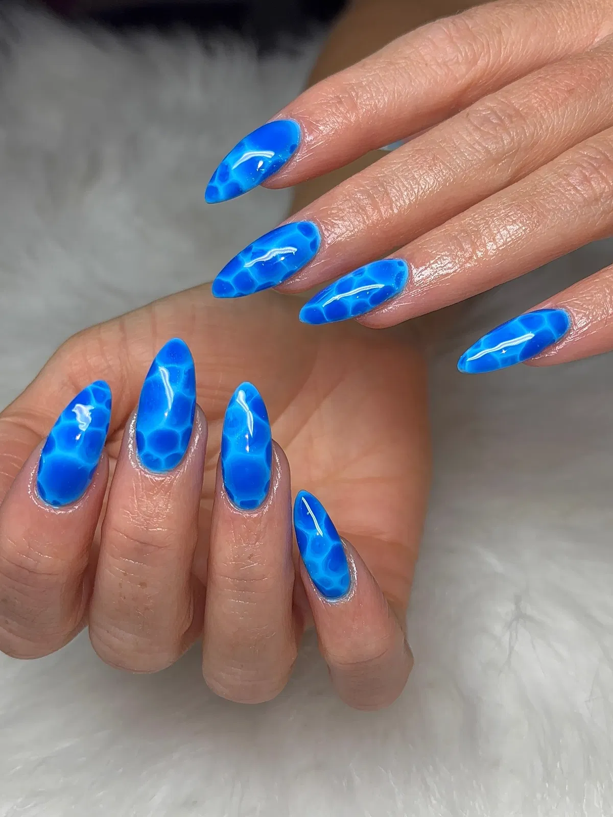 Bright blue water-ripple pattern on all nails