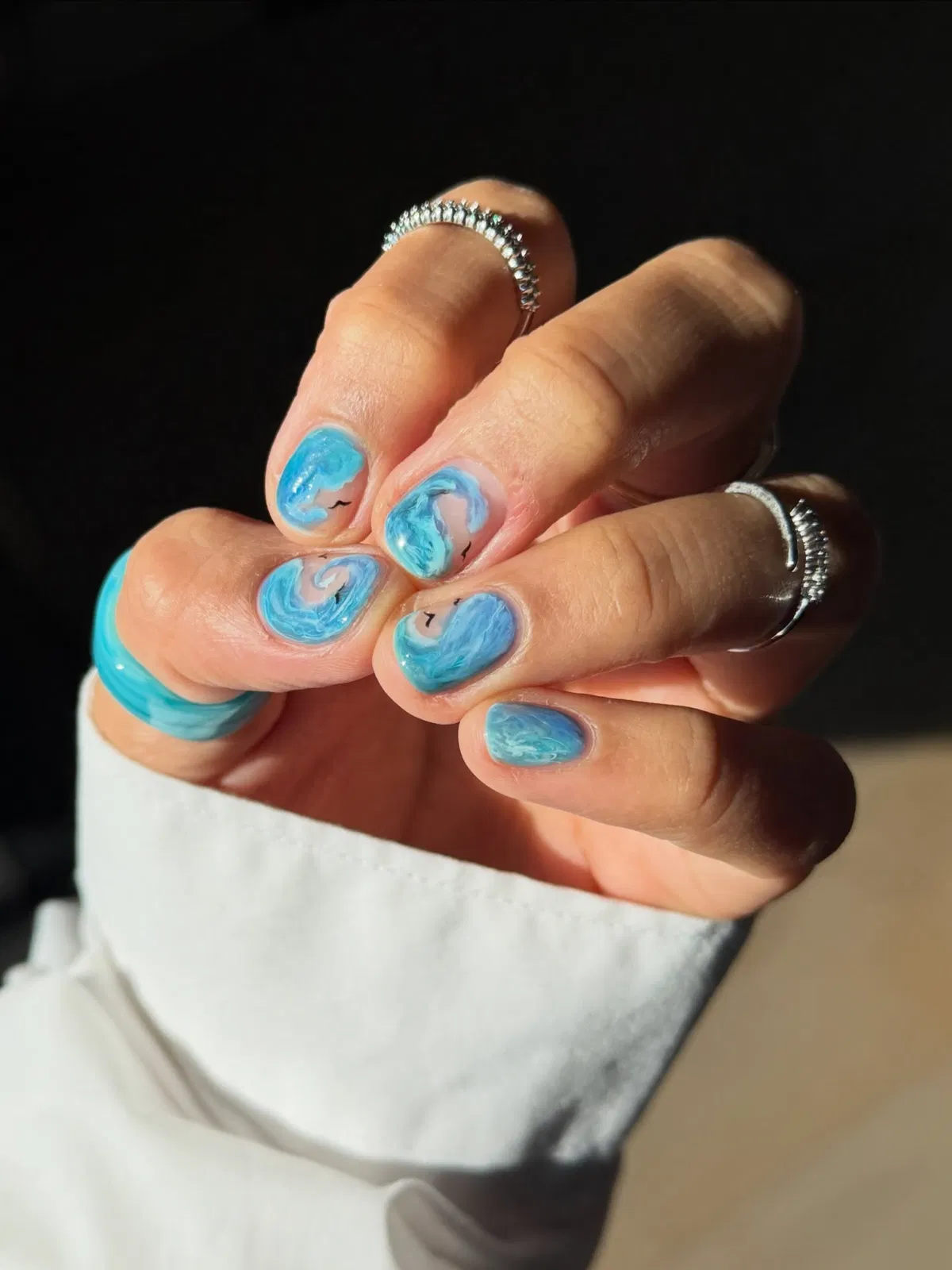 Short blue marble swirls with small black accents