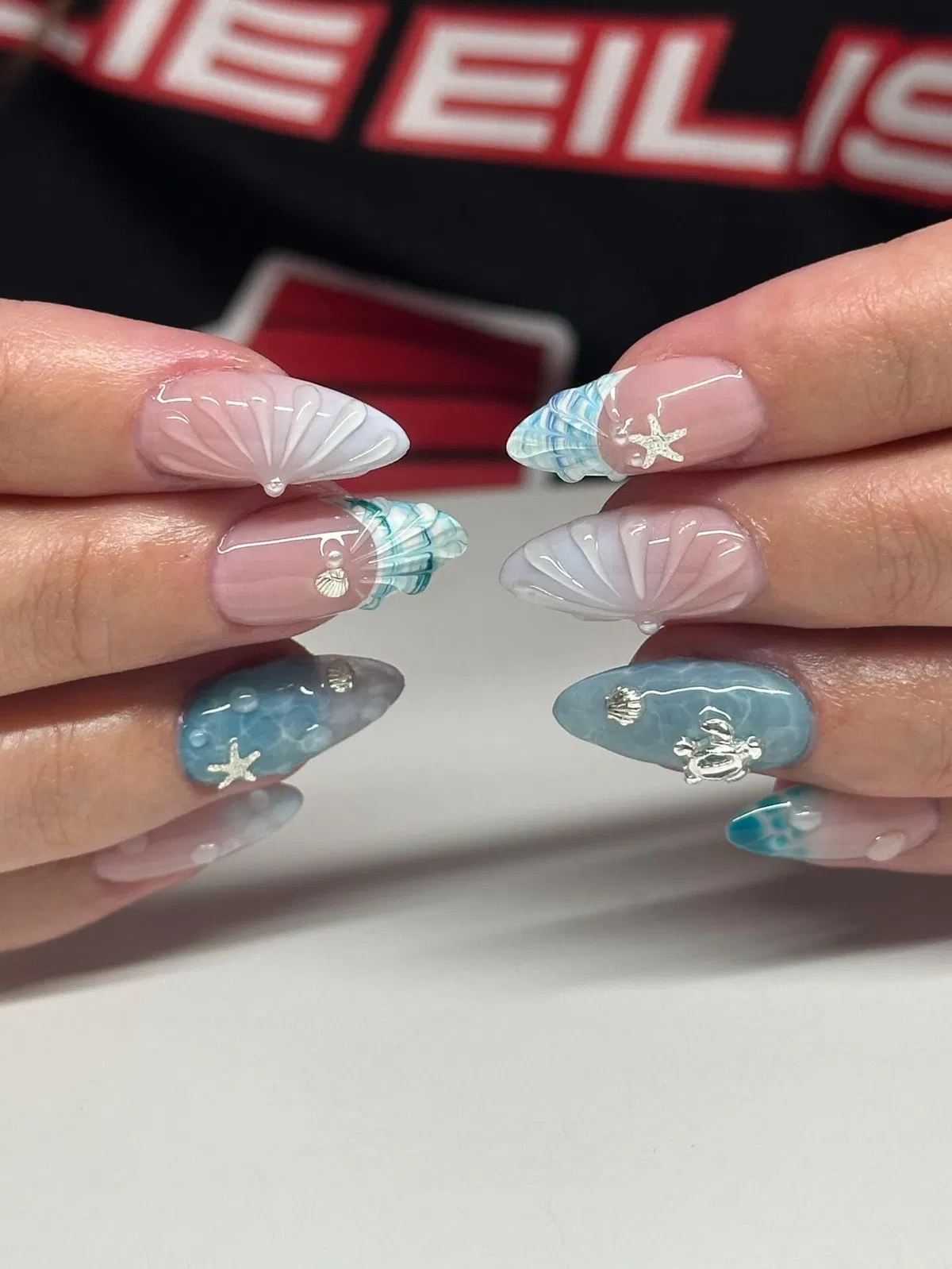 Close-up of 3D shell details with blue-gray sea charms