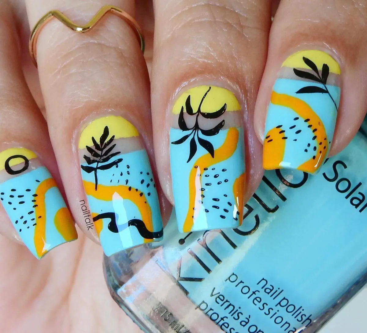Abstract blue-and-yellow nails with black botanical silhouettes