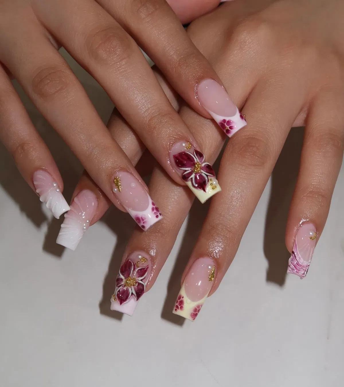 Burgundy floral square nails with gold accents and sculpted details