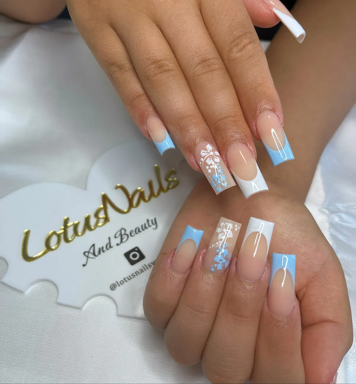 Light blue and white square French tips with floral line art