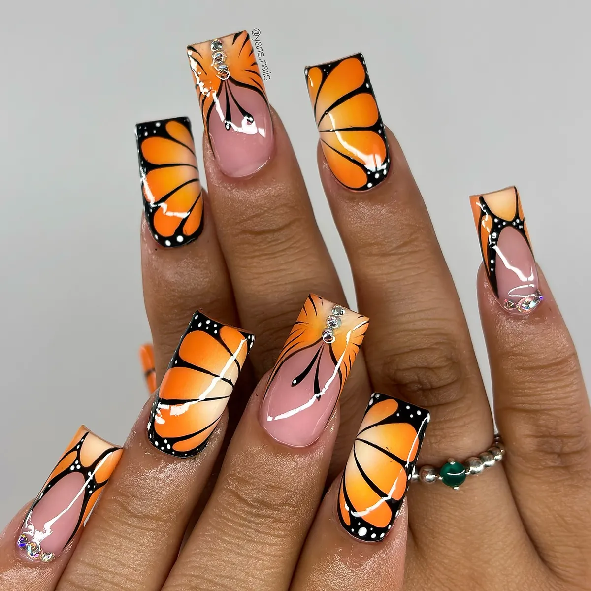 Orange-and-black wing pattern with rhinestone accents