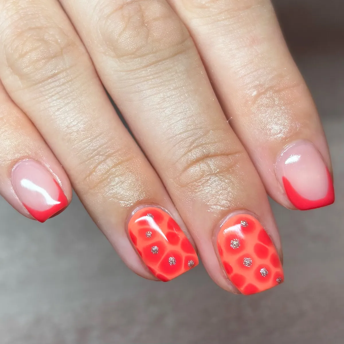 Red French tips with orange-red spotted accents and silver dots