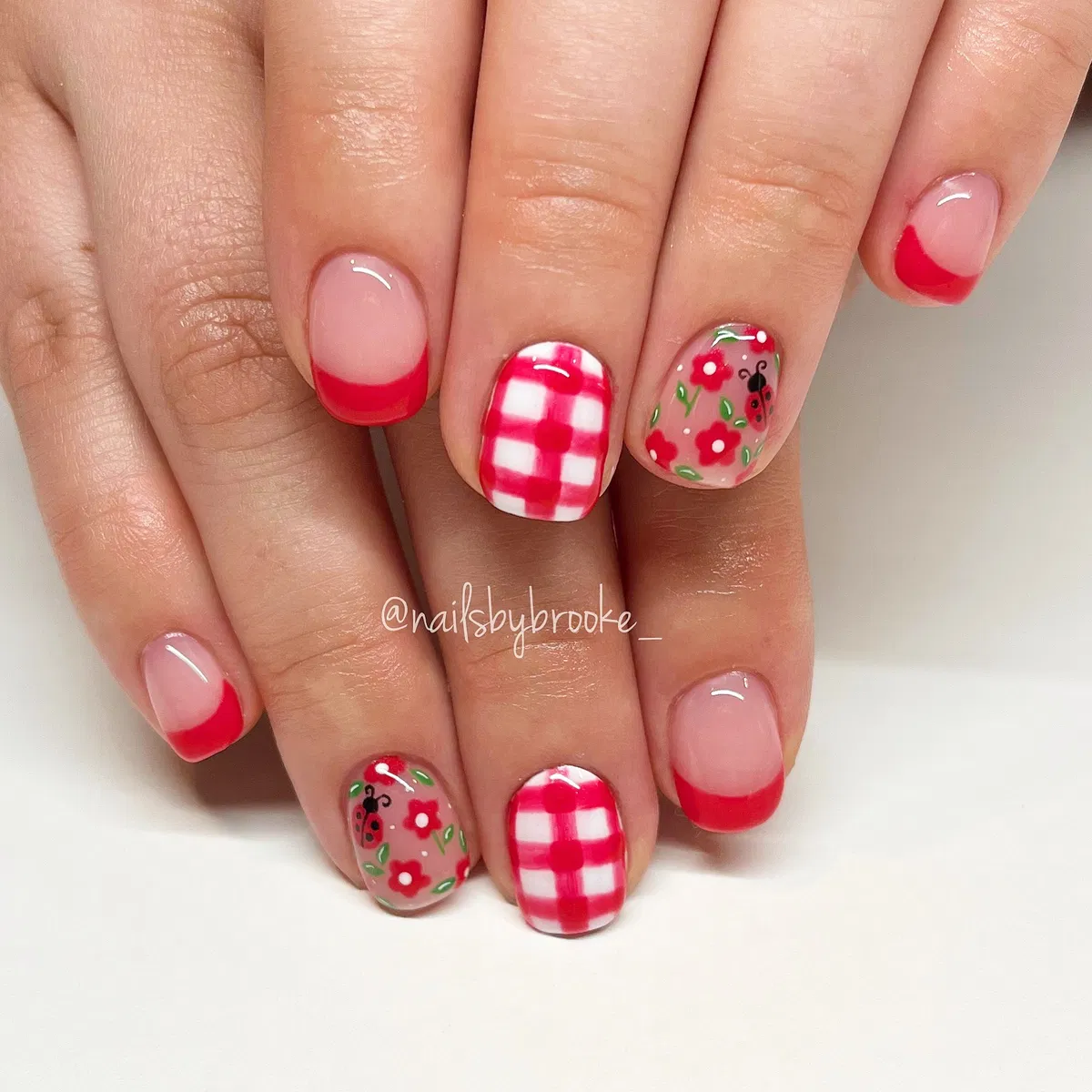 Red French tips with gingham and ladybug-floral accents