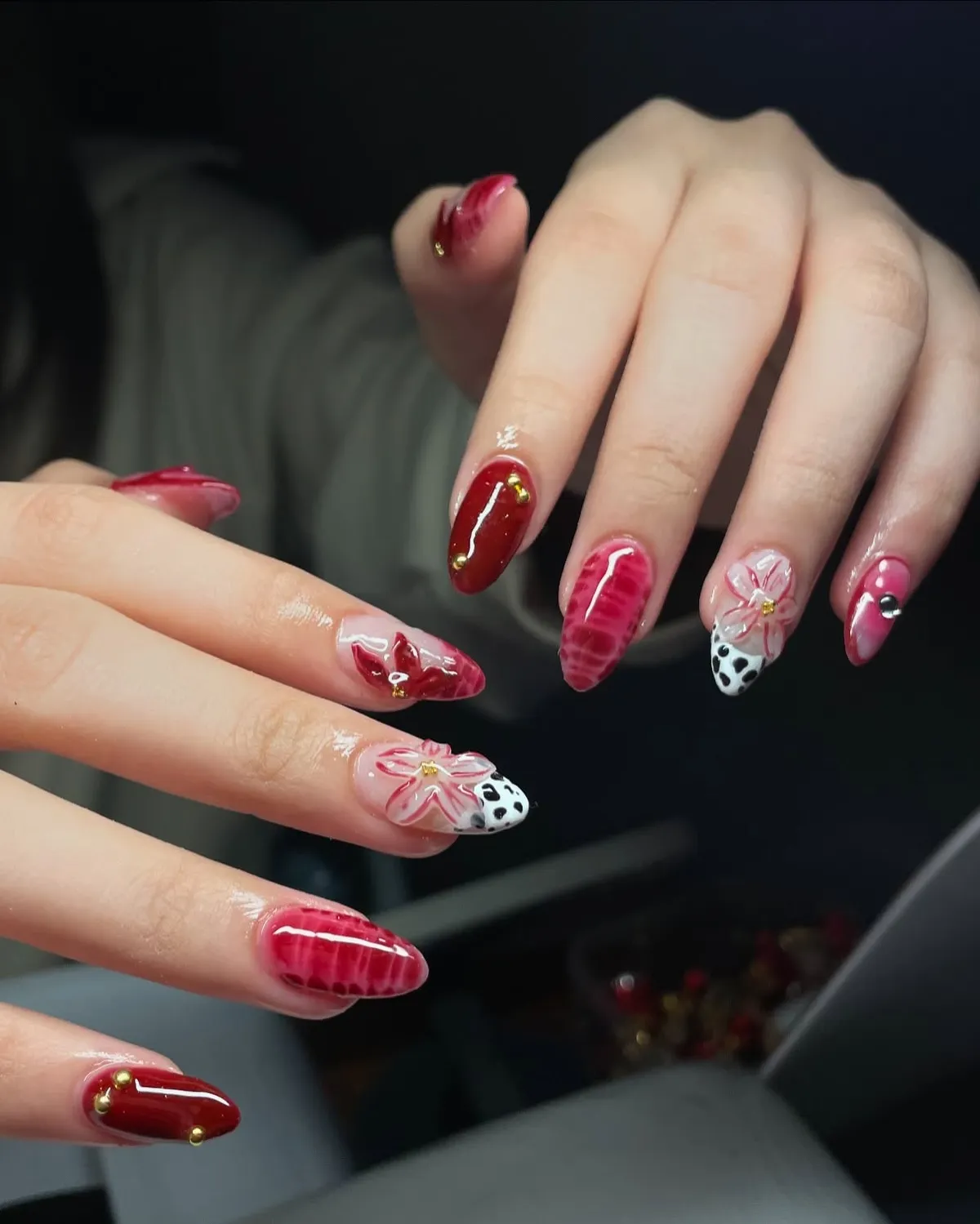 Deep red, pink patterns, floral outlines, and spotted tips with stud accents