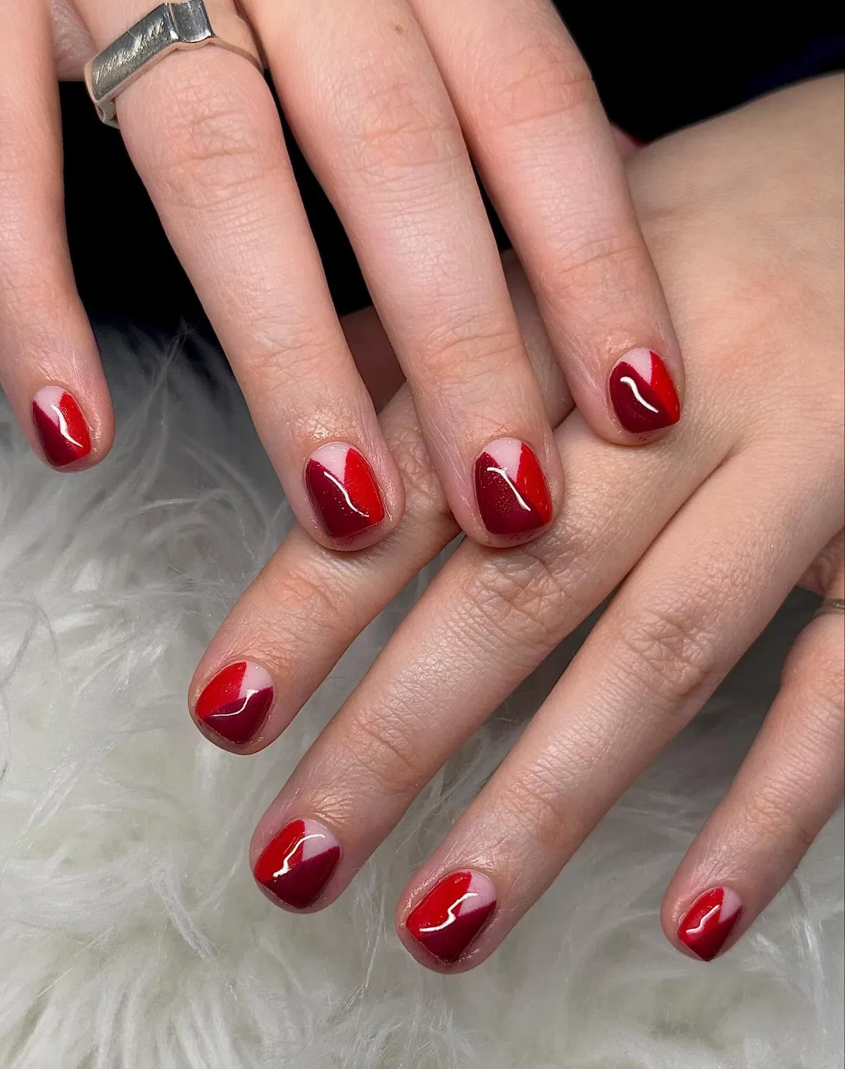 Two-tone diagonal red blocks on short glossy nails