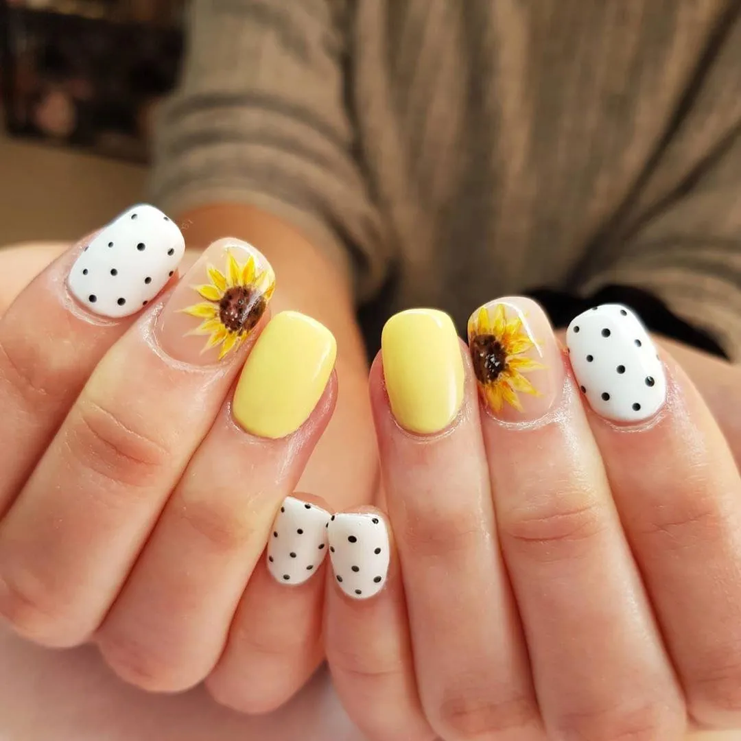 Pale yellow and polka dots with sunflower feature nails