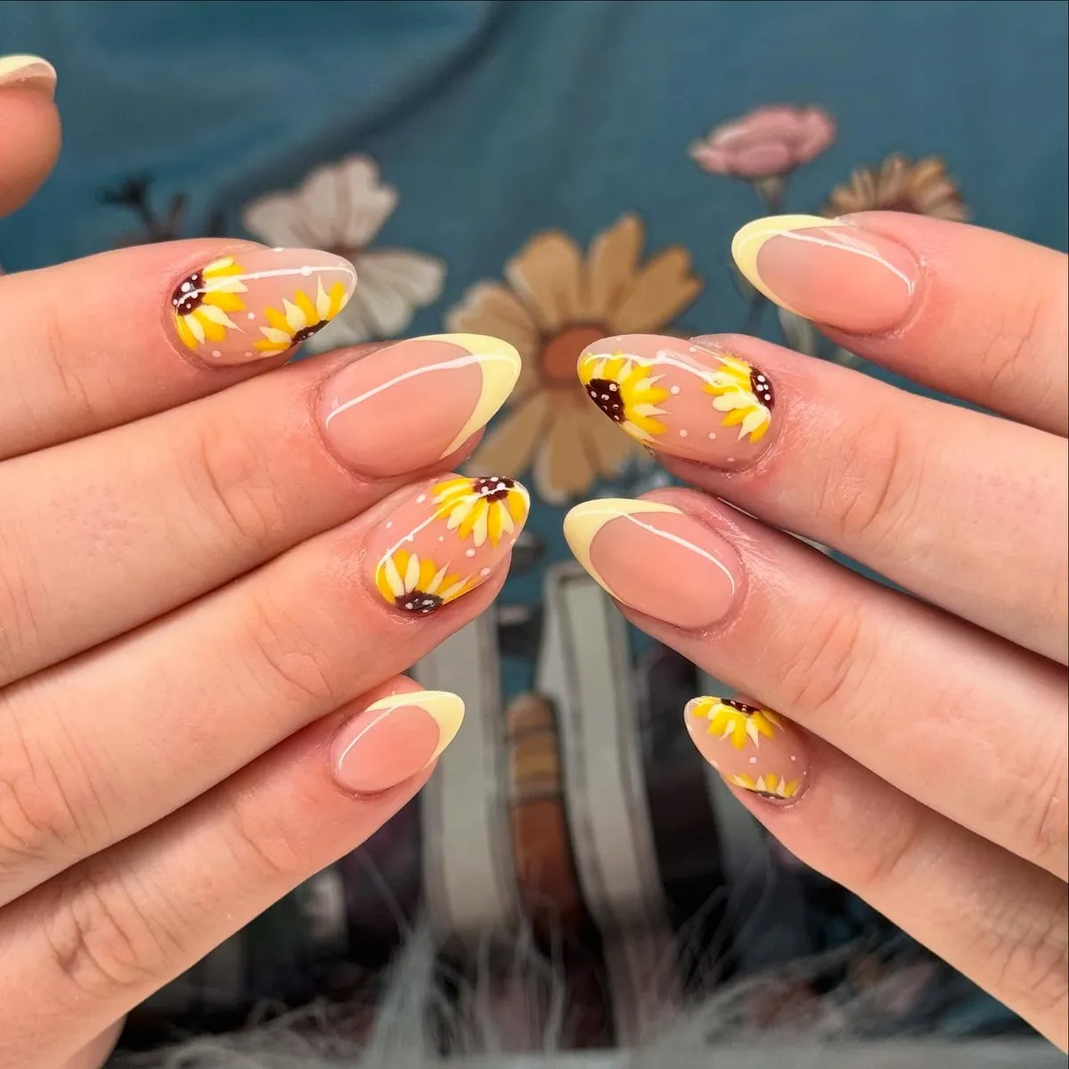 Nude almond nails with pale yellow tips and sunflowers