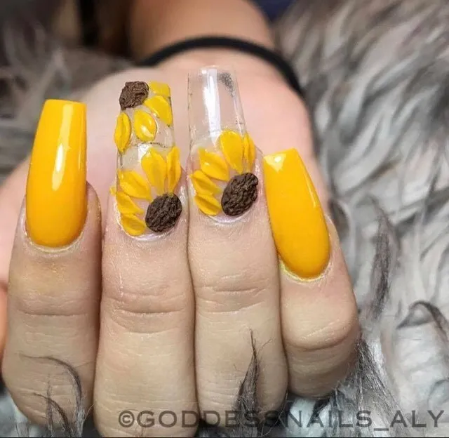 Bright yellow coffin nails with clear sunflower-embedded accents