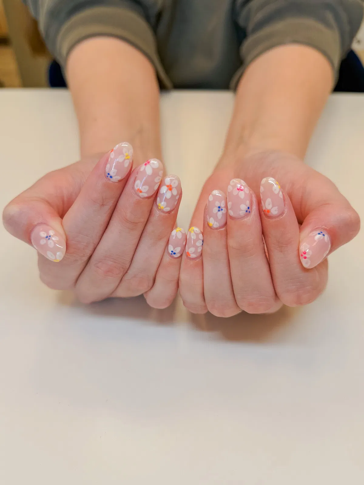 Sheer glossy nails with white flowers and colorful dot centers