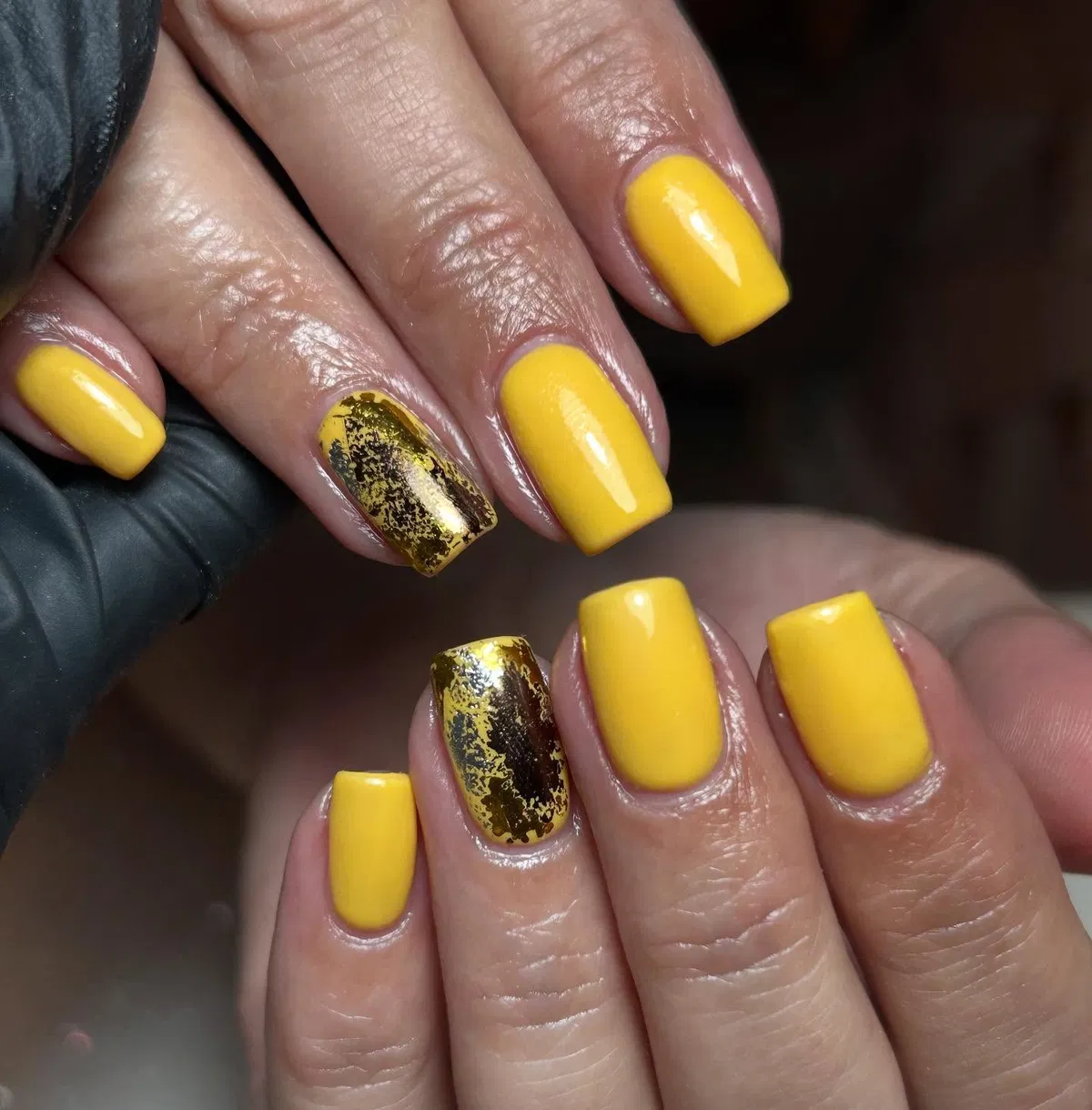Solid yellow nails with metallic foil accents
